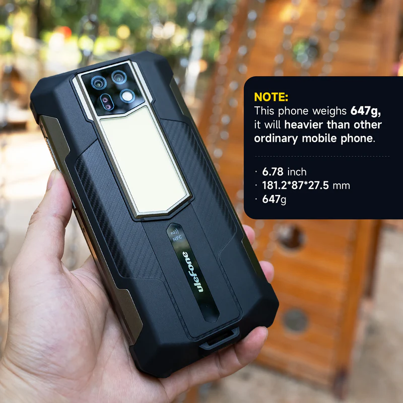 Egy kéz fog egy robusztus fekete okostelefont négy kamerával és NFC szimbólummal.