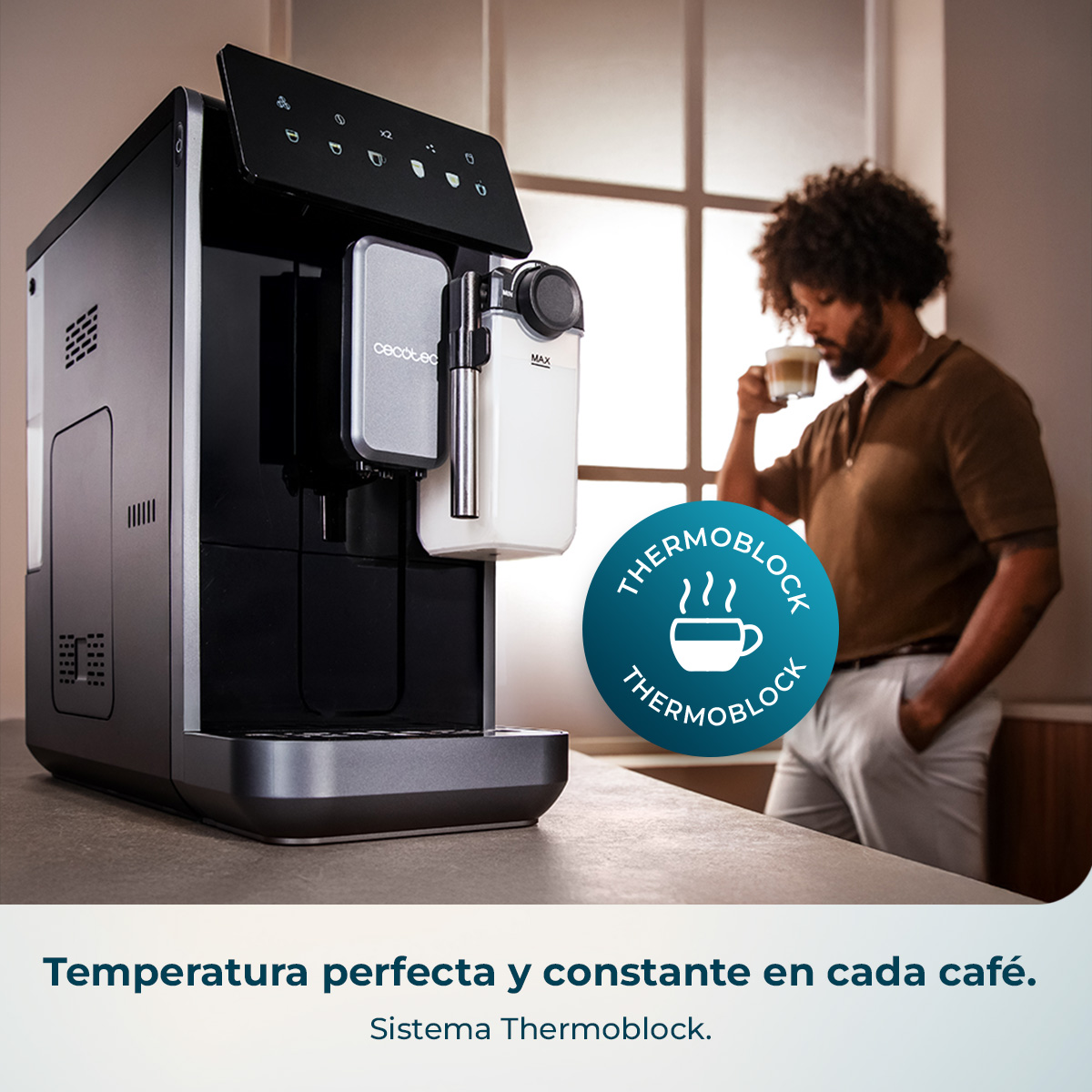 Una moderna cafetera negra sobre una encimera con un hombre bebiendo café al fondo.