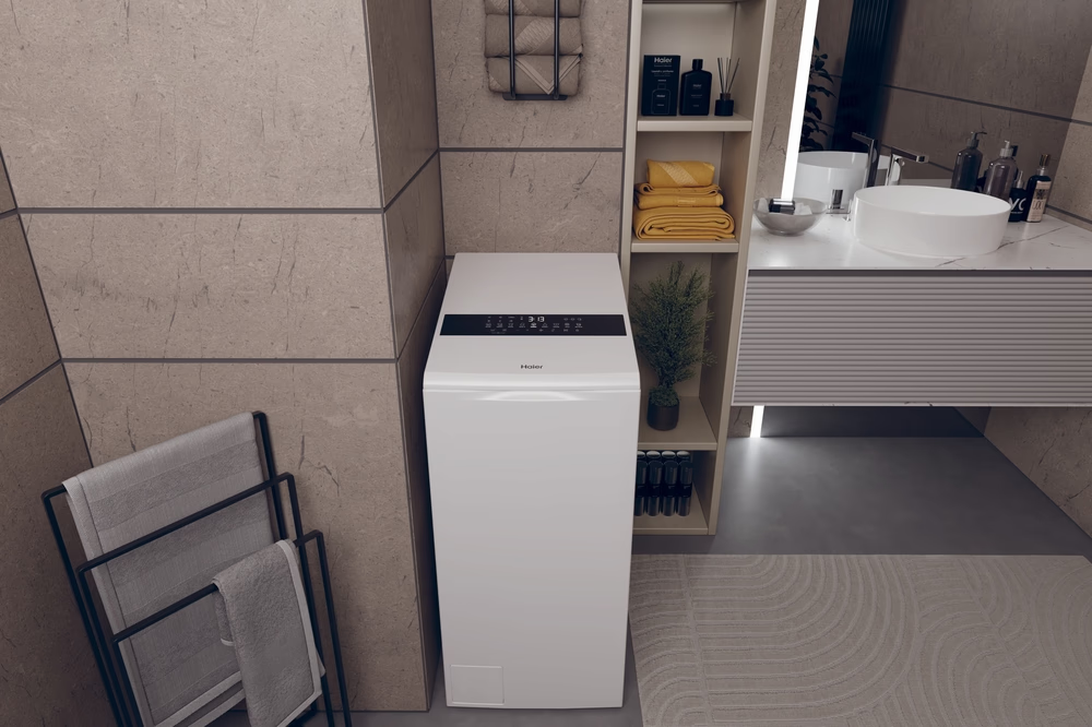 Una lavasciuga bianca si trova in un bagno moderno con pareti in pietra.