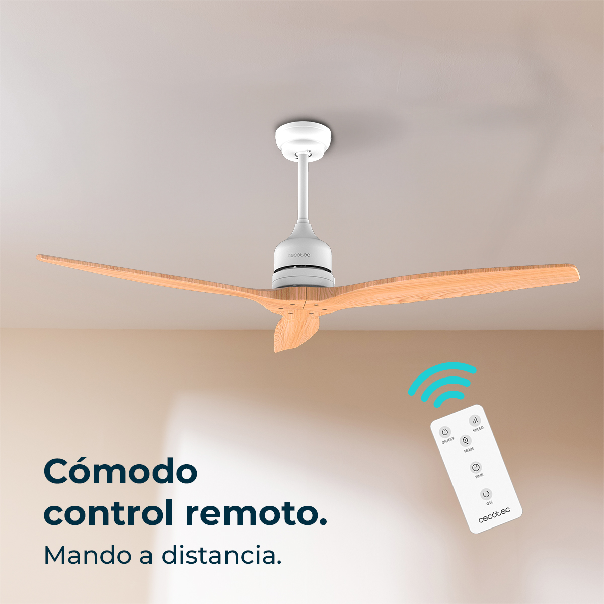 Un ventilador de techo con aspas de madera y un mando a distancia blanco en el suelo.