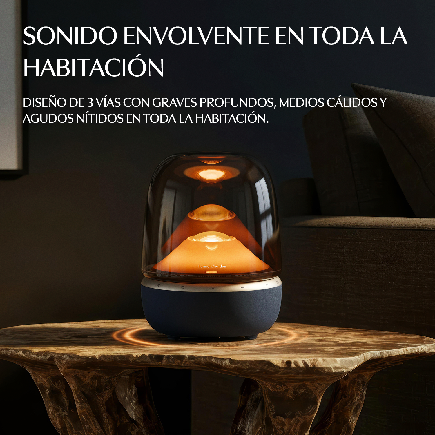 Un altavoz Harman Kardon iluminado sobre una mesa de madera.
