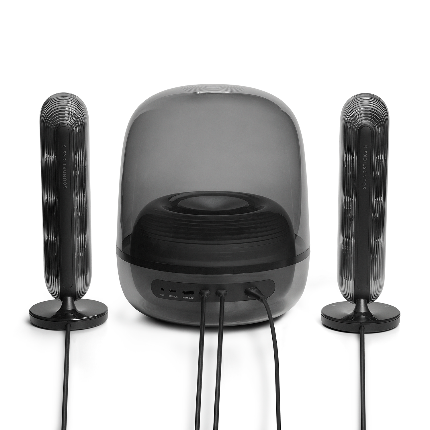 Dos altavoces negros altos y acanalados flanquean un subwoofer transparente en forma de cúpula con cables conectados.