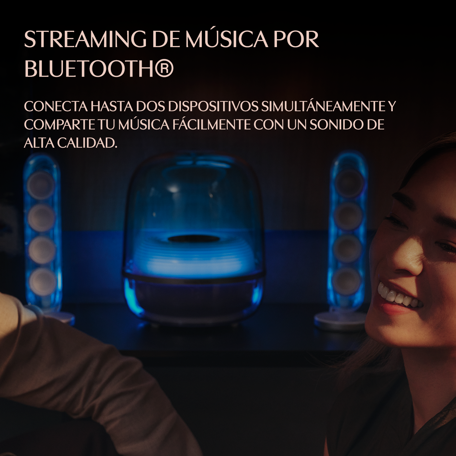 Un hombre y una mujer disfrutan música de altavoces Bluetooth con luz azul.
