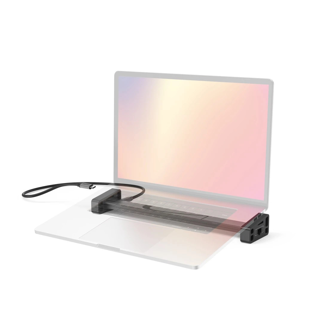 Un concentrador USB-C negro está conectado a un portátil sobre una superficie blanca.