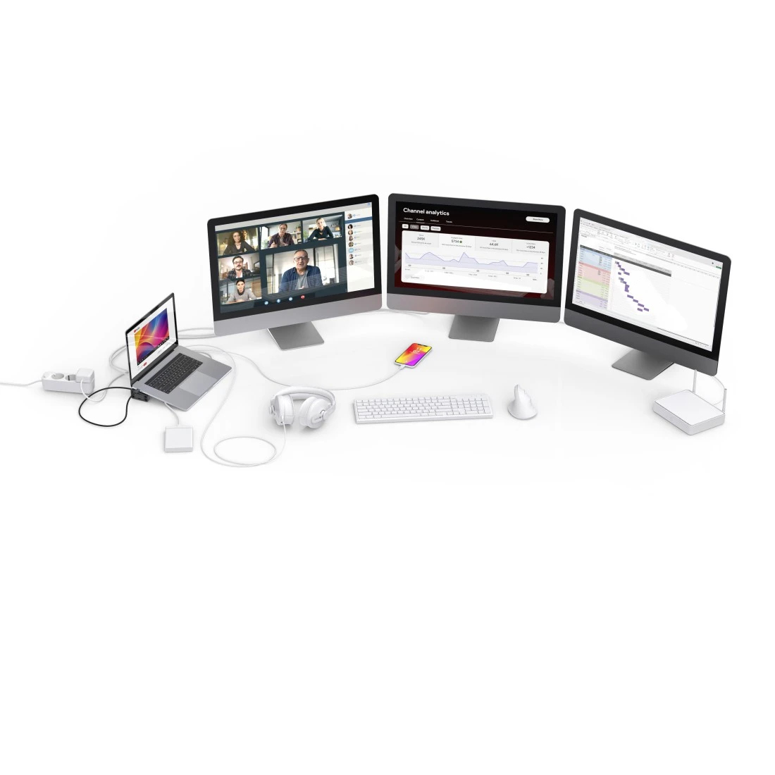 Una configuración de múltiples monitores con portátil, auriculares y teléfono en un escritorio blanco.