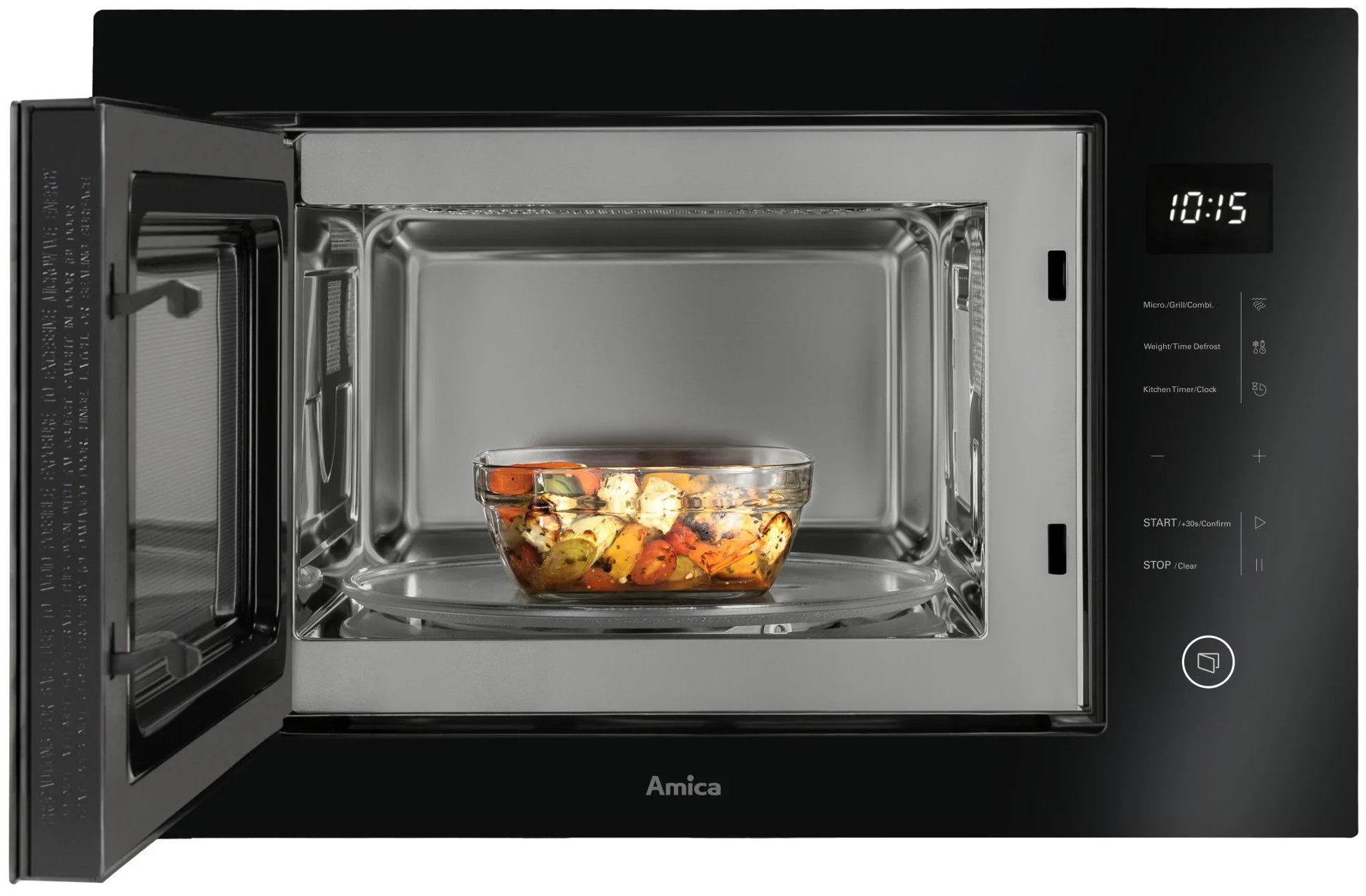 Szklana miska z pieczonymi warzywami stoi na obrotowym talerzu otwartej kuchenki mikrofalowej.