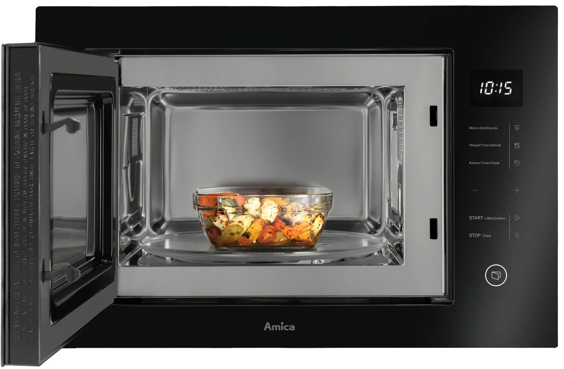 Szklana miska pieczonych warzyw stoi w otwartej czarnej mikrofalówce.