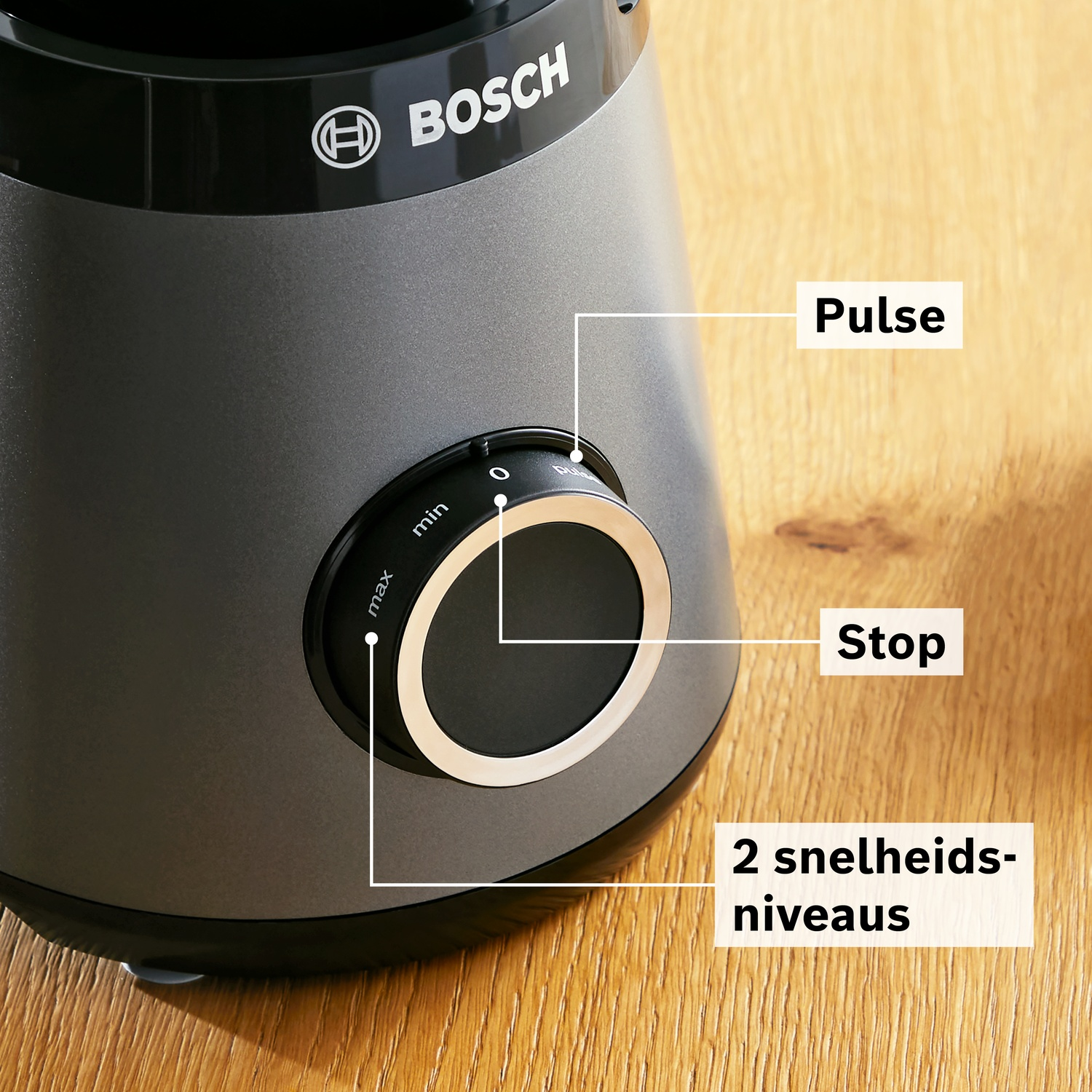 Gray Bosch blender with dial for speed, stop, and pulse on a wooden background.