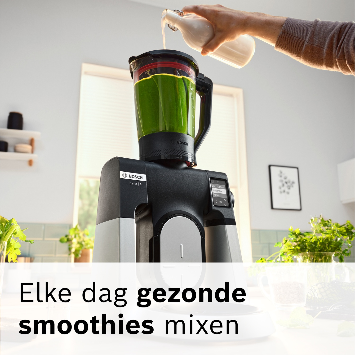 Een hand giet vloeistof in een blender met groene smoothie massa.