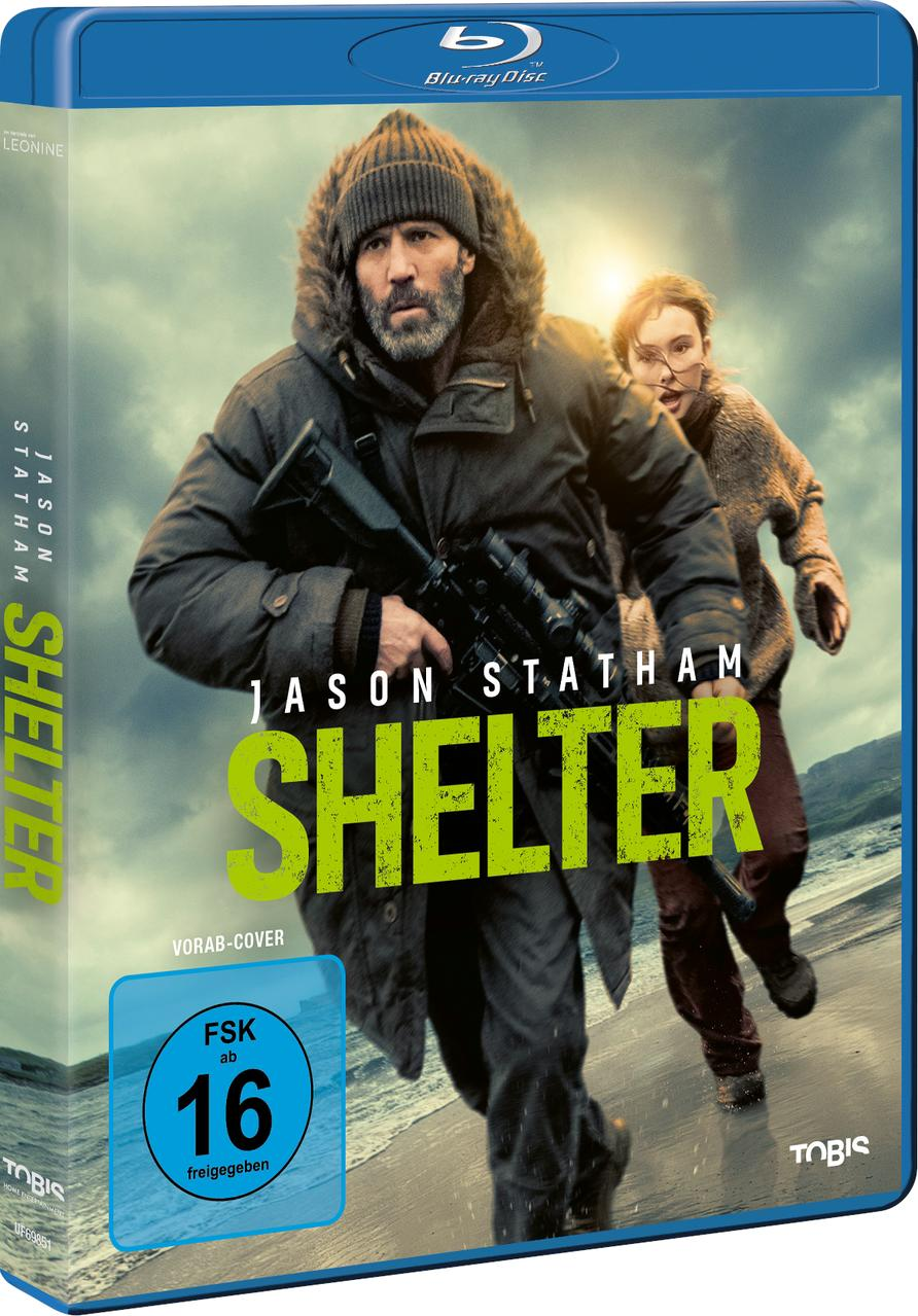 Jason Statham und ein Mädchen rennen am Strand. Er trägt eine Winterjacke und hält ein Gewehr.