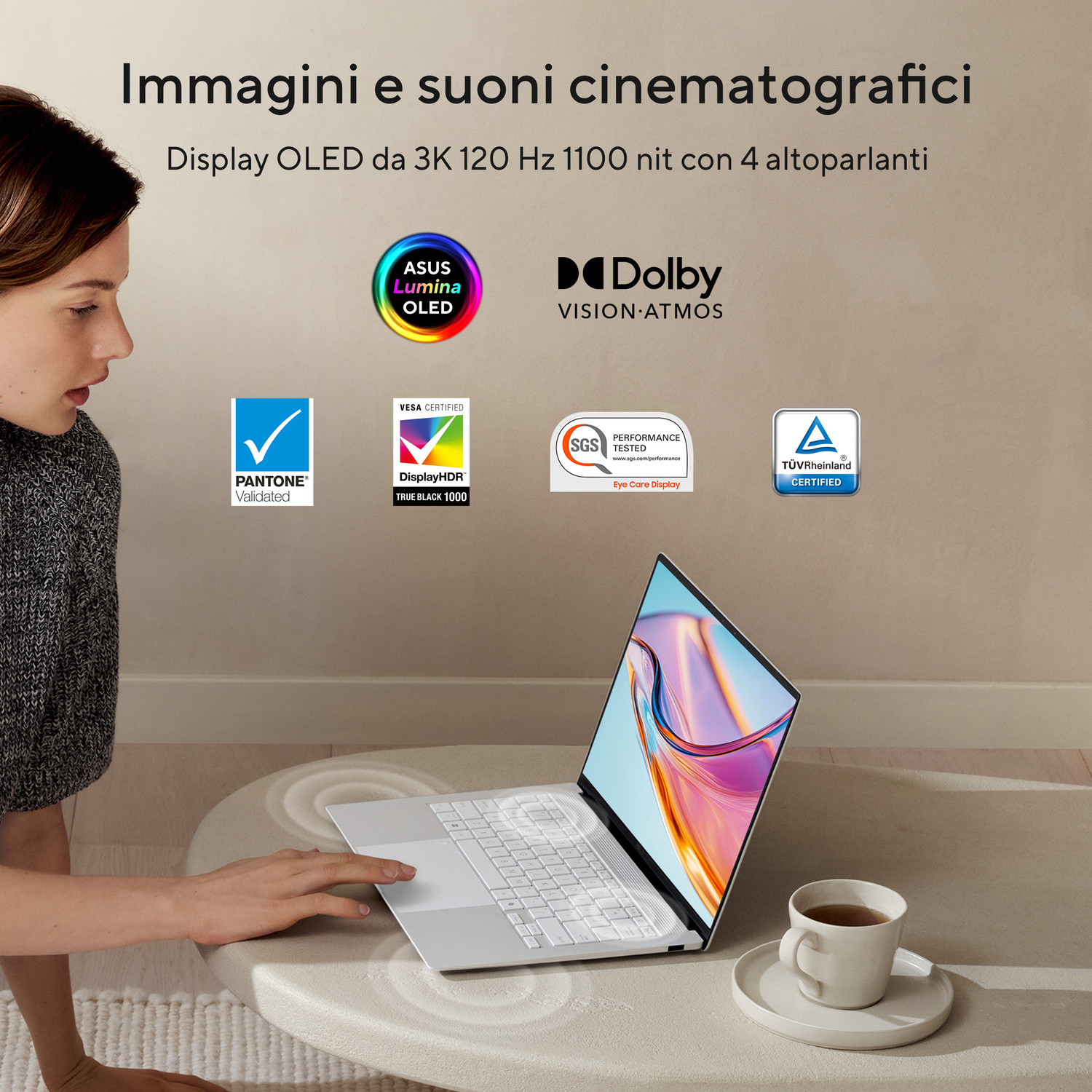 Una donna tocca un laptop con display OLED, accanto a una tazza di tè.