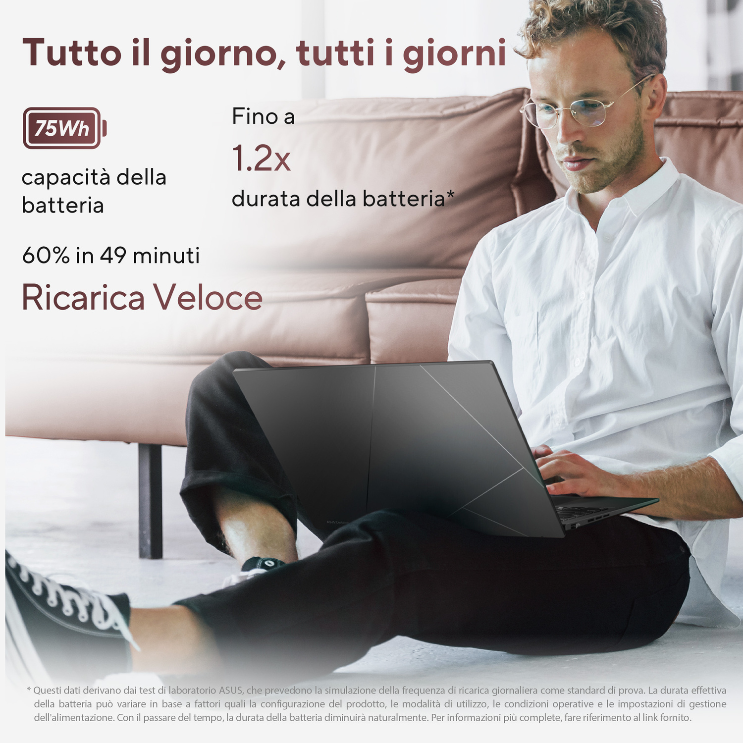 Un uomo seduto a terra usa un laptop. Testo sulla durata della batteria.