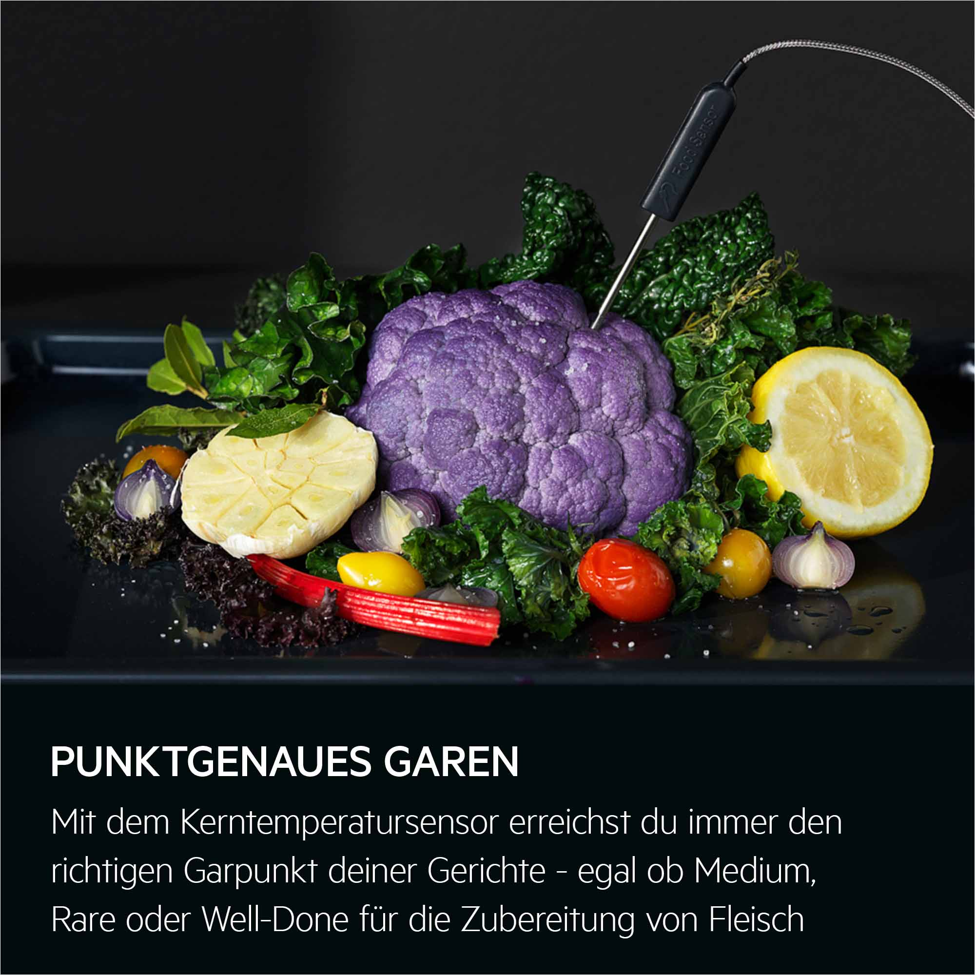Ein Fleischthermometer steckt in violettem Brokkoli, neben Knoblauch, Zitronenscheibe und Gemüse.