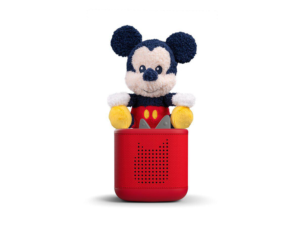 Micky Maus Plüschfigur sitzt auf einem roten Lautsprecher mit Lochmuster.