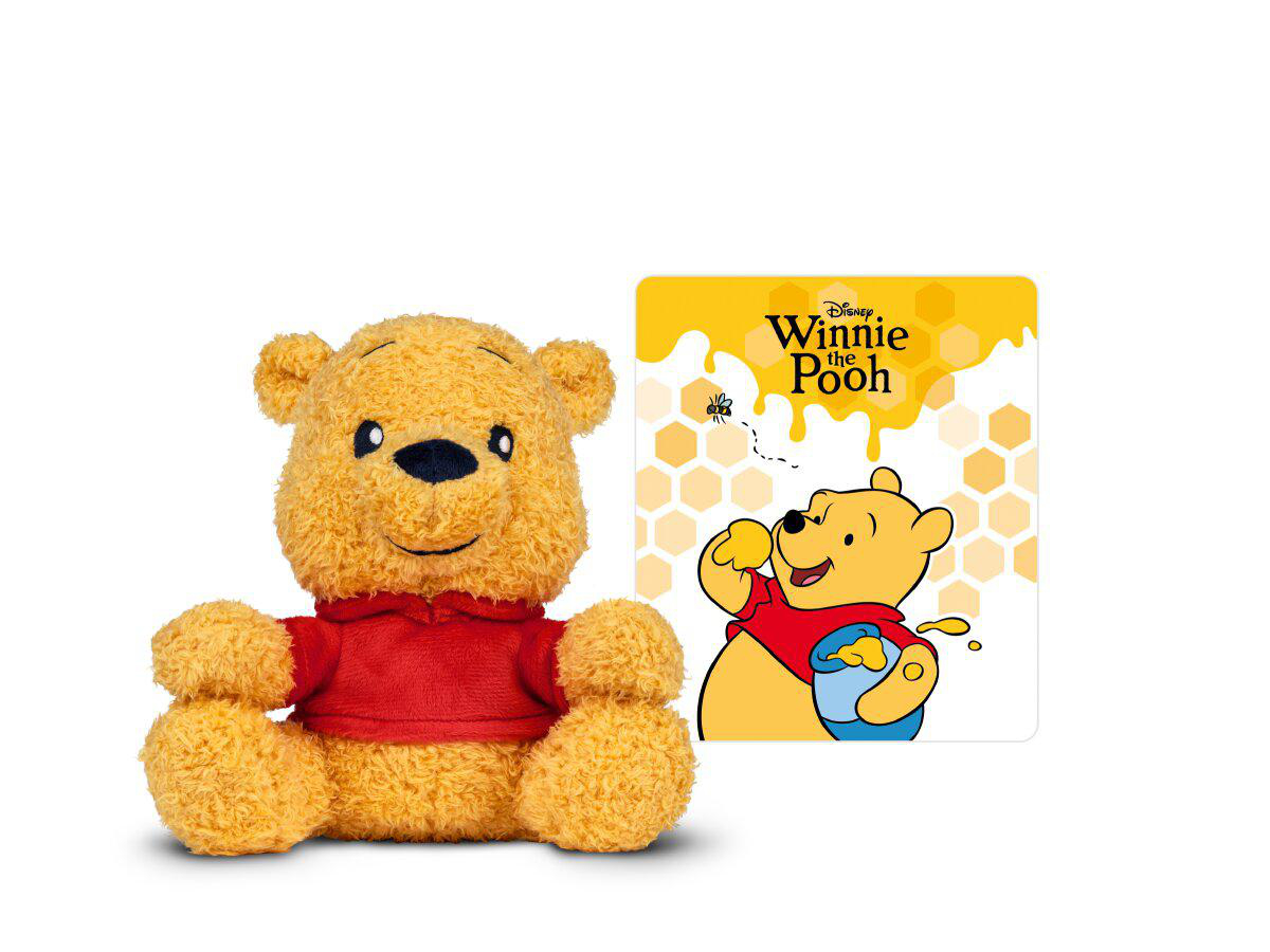 Ein Winnie Puuh Plüschtier sitzt neben einer Zeichnung von Winnie Puuh mit Honig.
