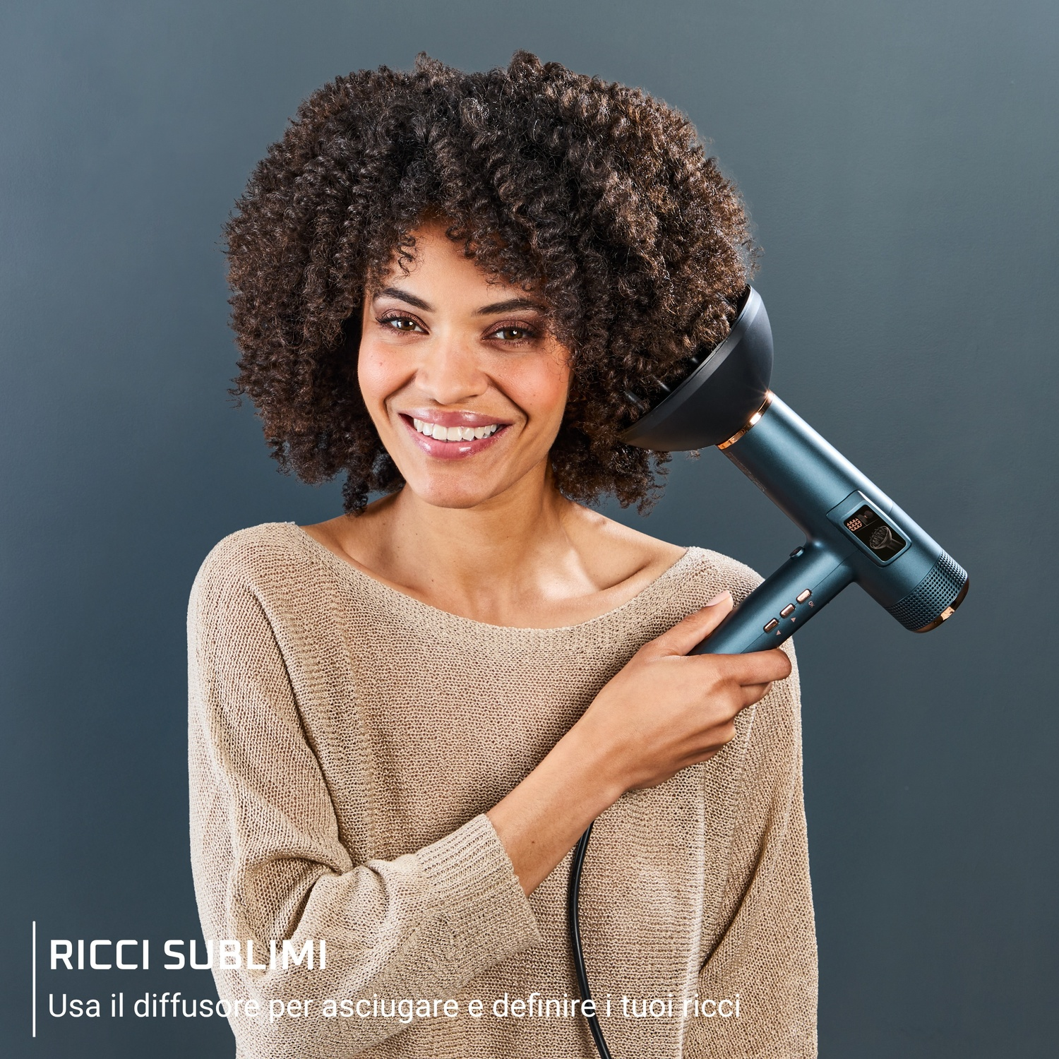Donna con capelli ricci tiene in mano un asciugacapelli diffusore blu.
