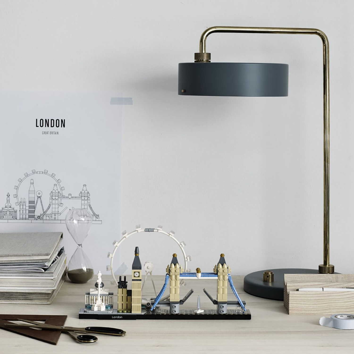 Desk with London landmarks model, books, hourglass, lamp, and stationery.