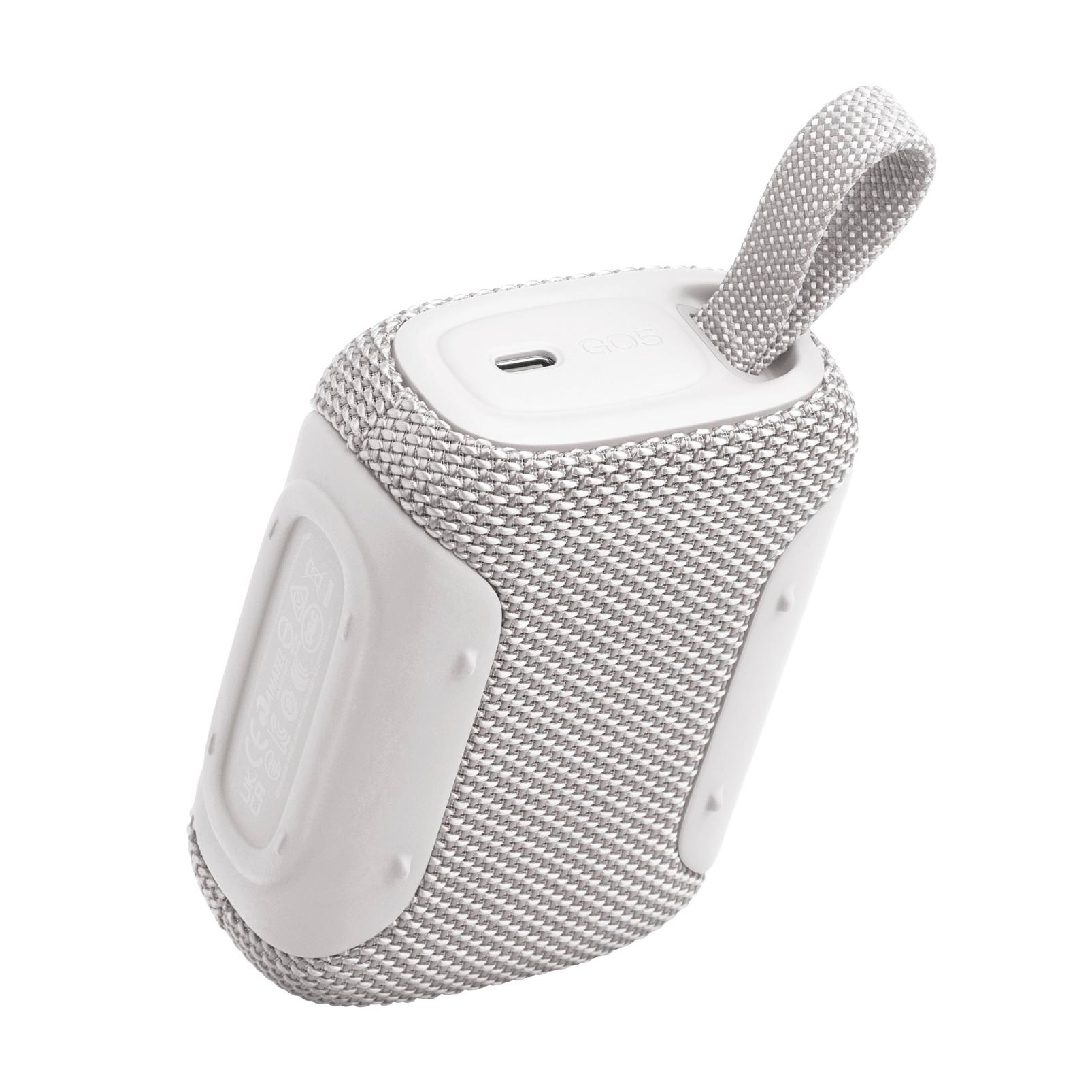 Ein kompakter, grauer Bluetooth-Lautsprecher mit einem weißen Tragegriff und Ladeanschluss.