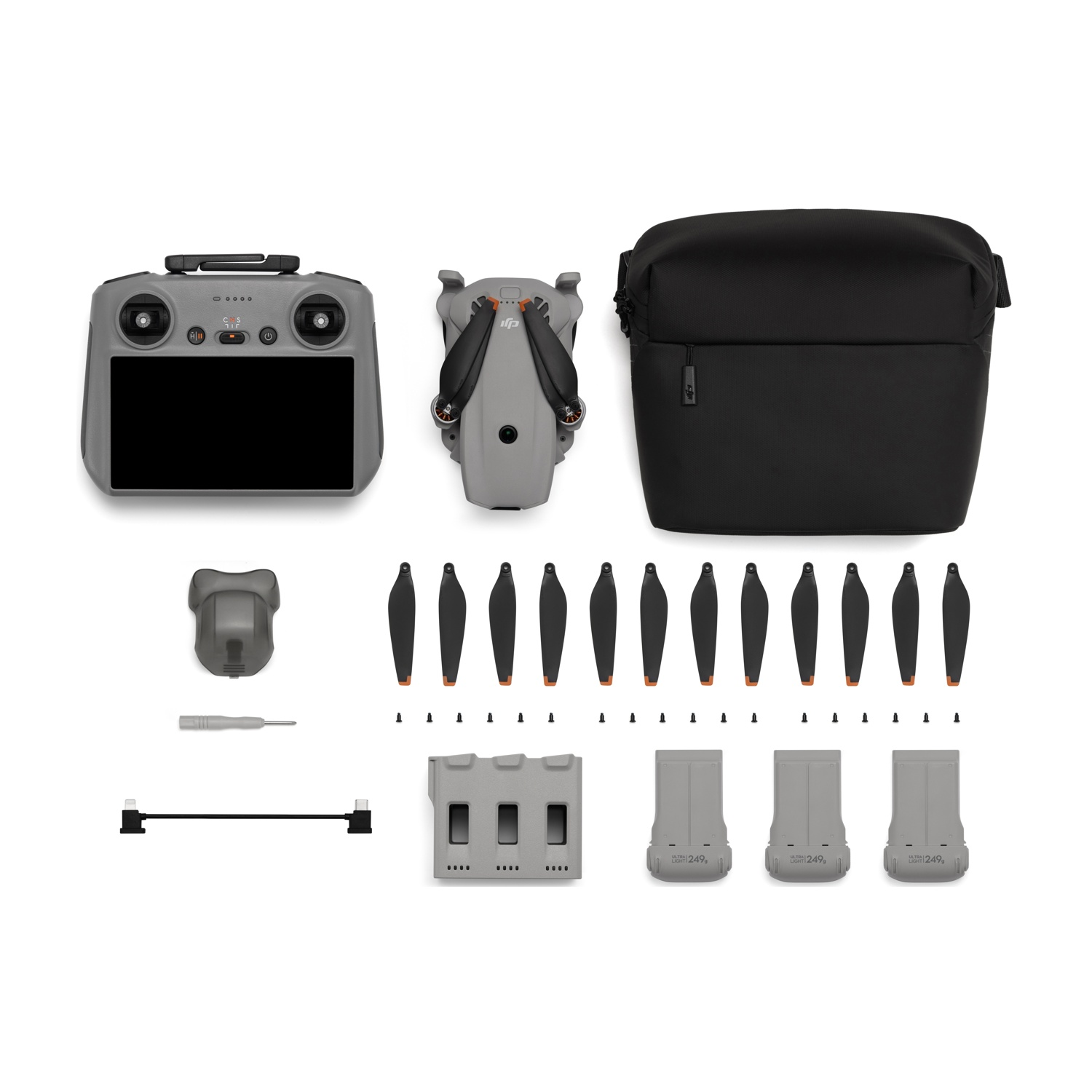 Drone, telecomando, borsa e accessori disposti su sfondo bianco.