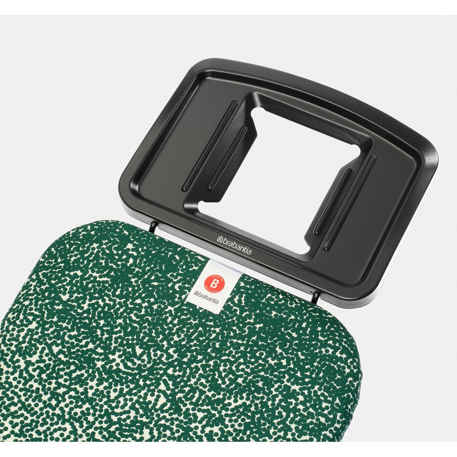 A black ironing board holder with a green and white dotted pattern fabric cover.