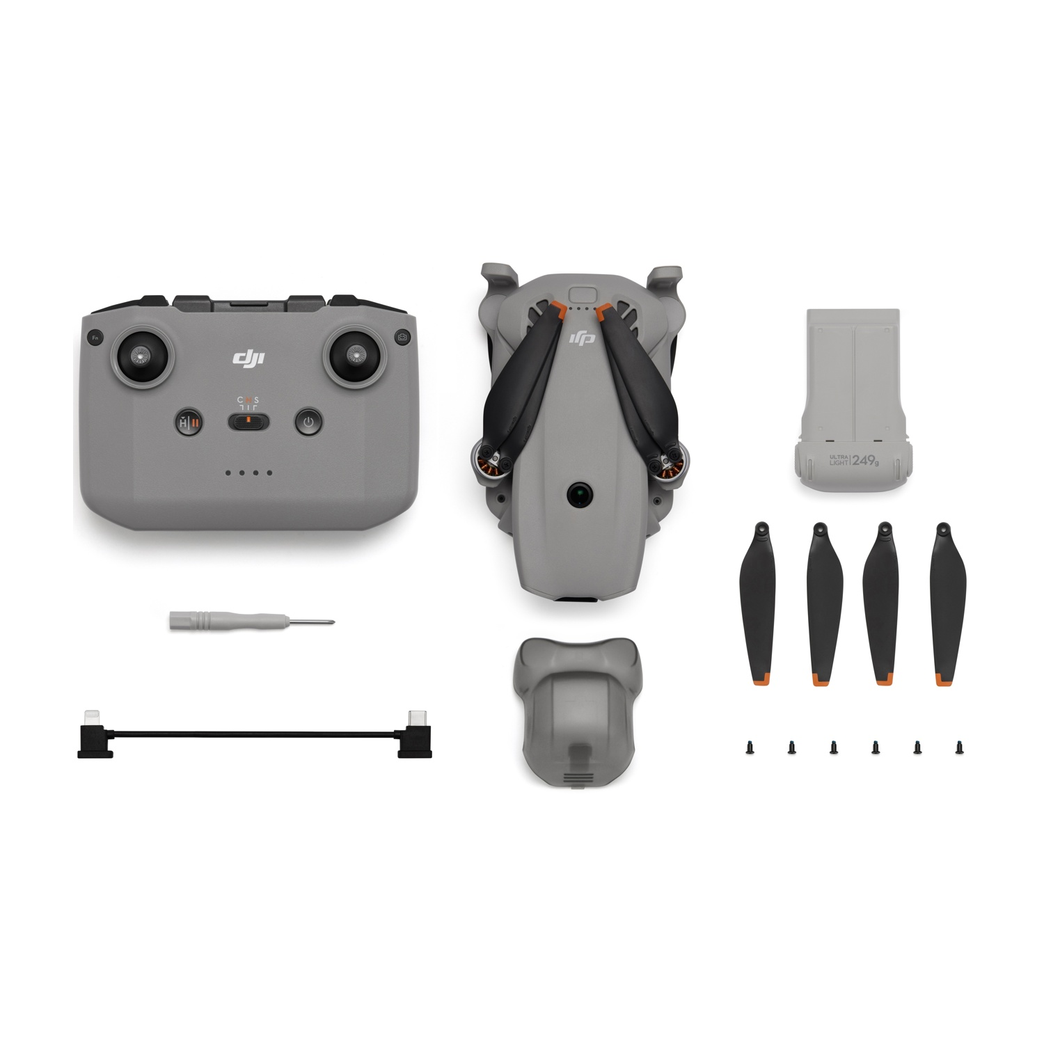 Controller DJI grigio, drone, batteria, eliche, cavo e cacciavite.