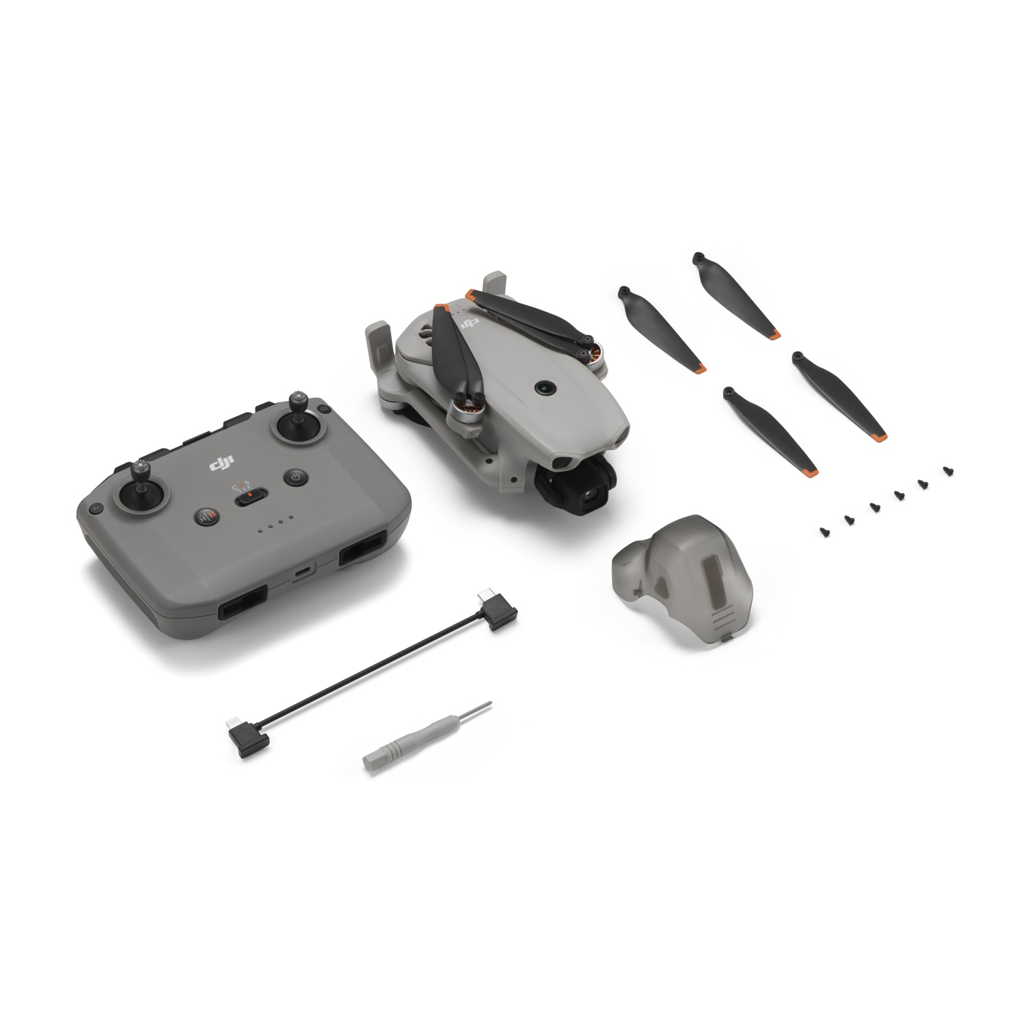 Drone DJI Mini 3 Pro grigio con accessori: telecomando, eliche di ricambio, viti, cavo e attrezzo.
