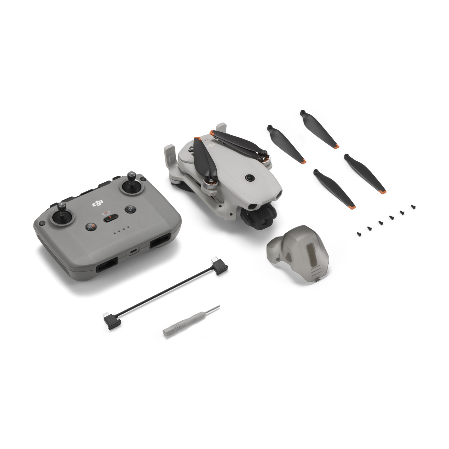 Controller DJI grigio, drone, eliche, viti e accessori su sfondo bianco.
