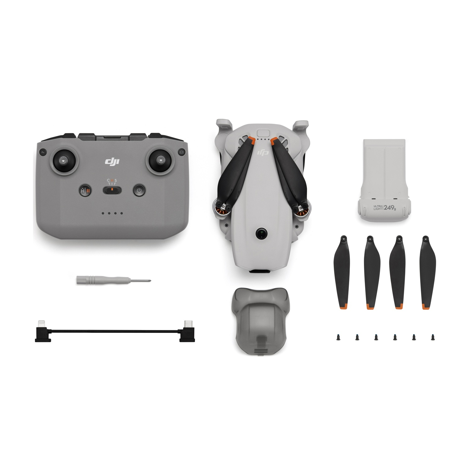Controller grigio, drone, batteria, eliche di ricambio e accessori su sfondo bianco.