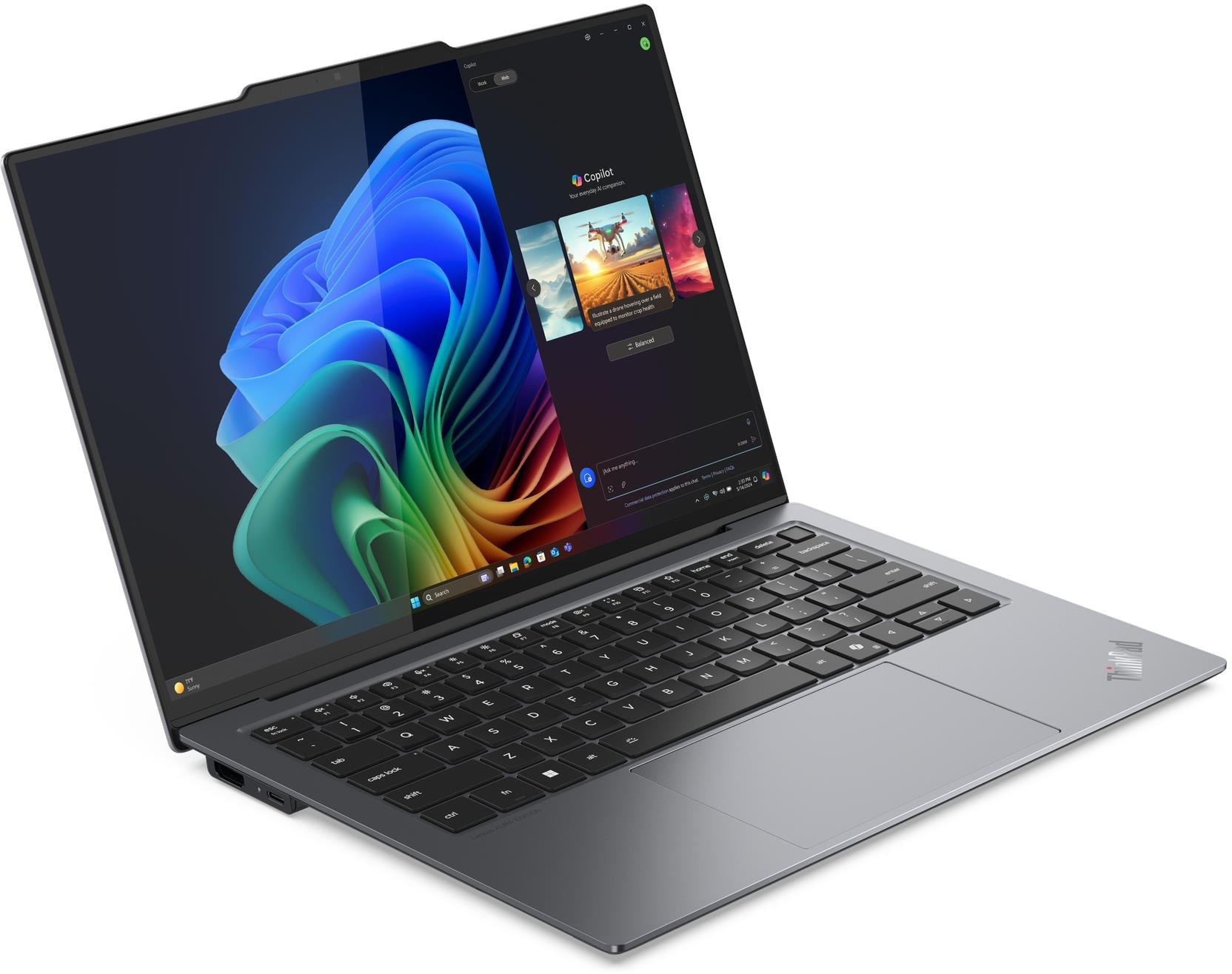 Egy szürke laptop színes háttérképpel és nyitott Copilot ablakkal.