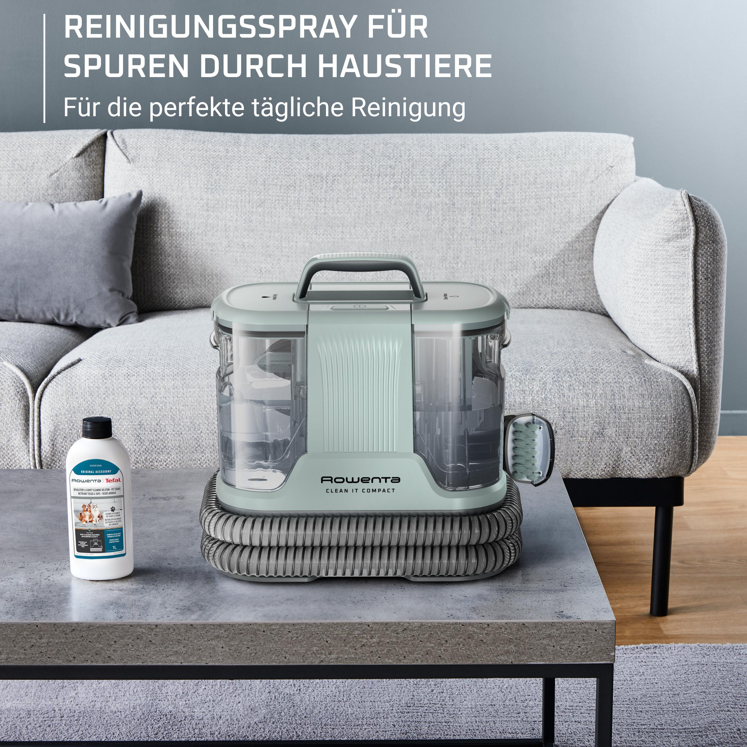 Ein Reinigungsgerät mit Flasche steht auf einem Tisch vor einem Sofa.