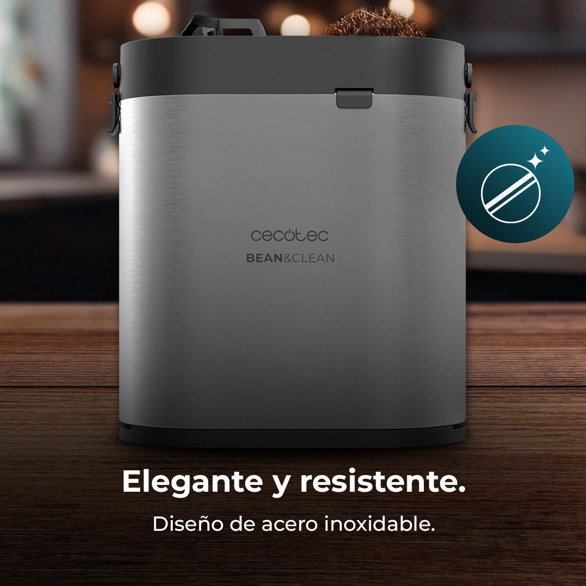 Elegante cafetera de metal cepillado con tapa negra, sobre superficie de madera.