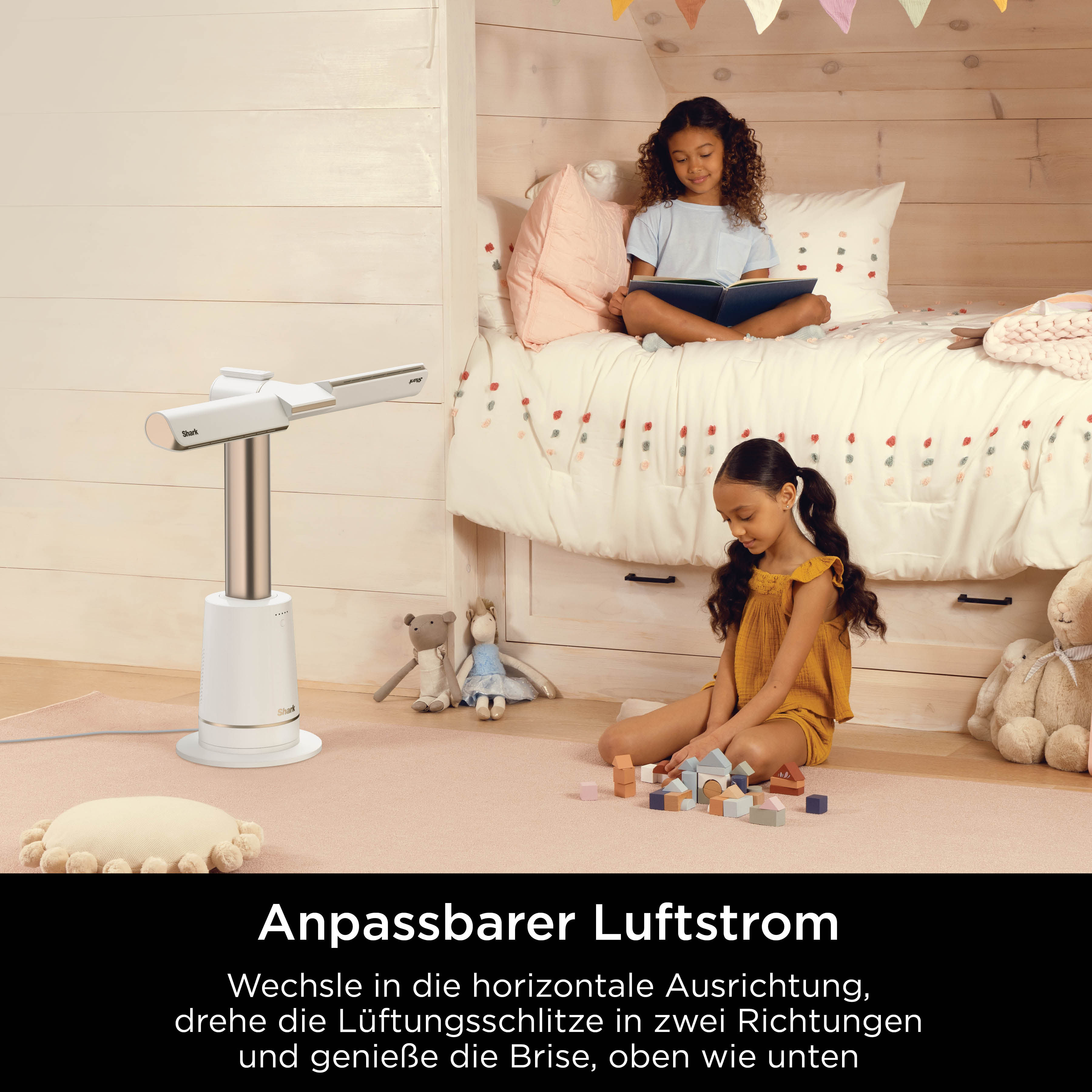 Zwei Mädchen spielen im Zimmer. Eines liest, das andere baut.