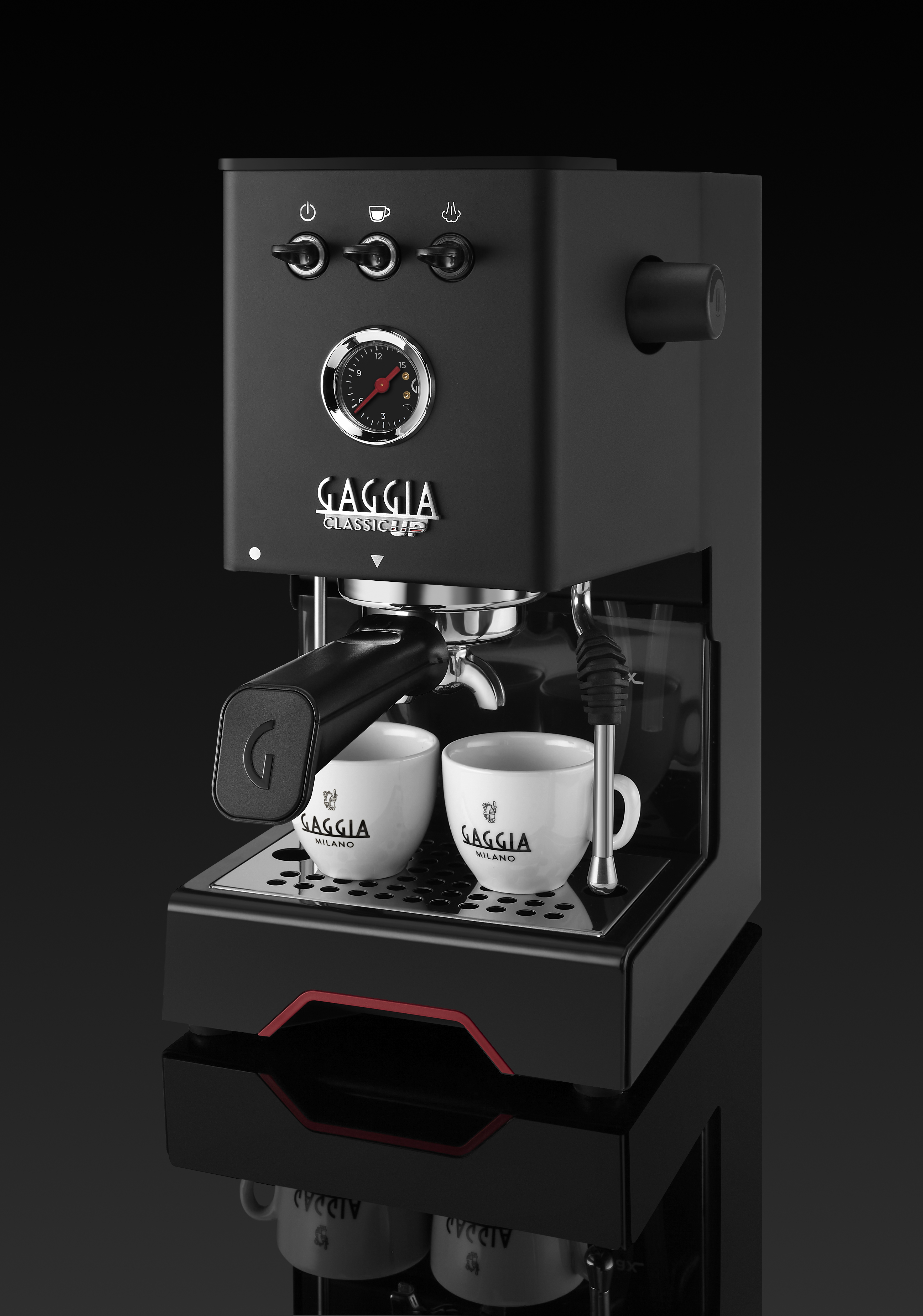Schwarze Espressomaschine mit zwei weißen Tassen, Druckanzeige und Dampflanze.