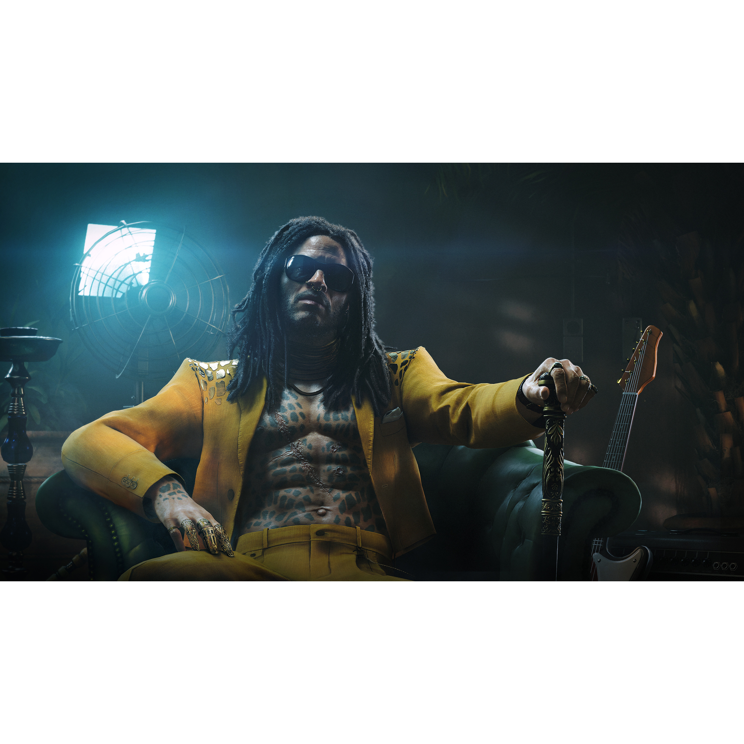 Man with dreadlocks and sunglasses sits on a green sofa with a guitar in the background.