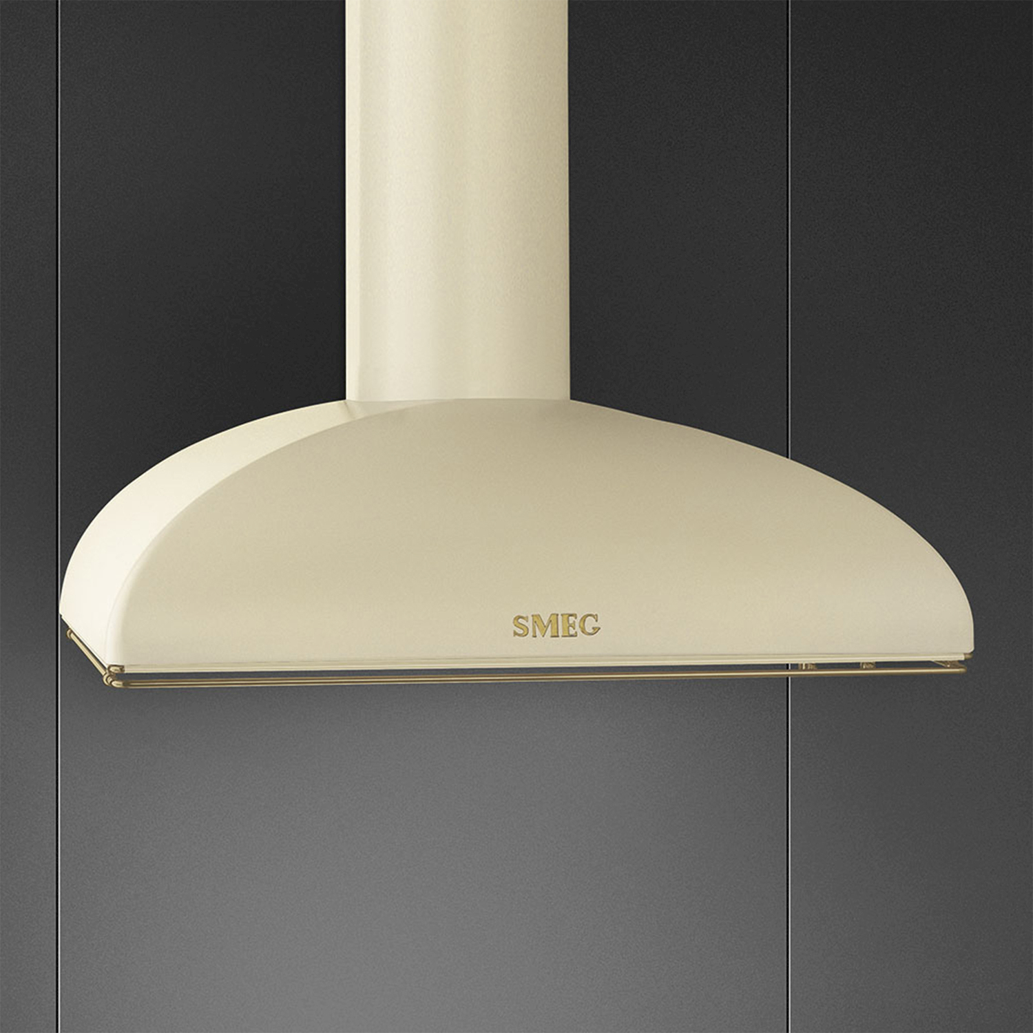Cappa aspirante color crema con logo SMEG dorato sopra pensili scuri.