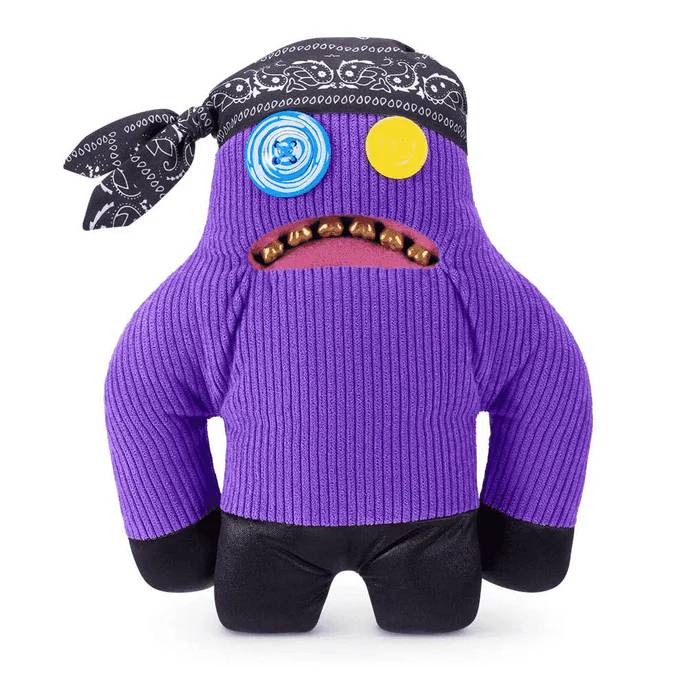 Un monstruo de peluche morado con bandana, ojos de botón y boca abierta con dientes.
