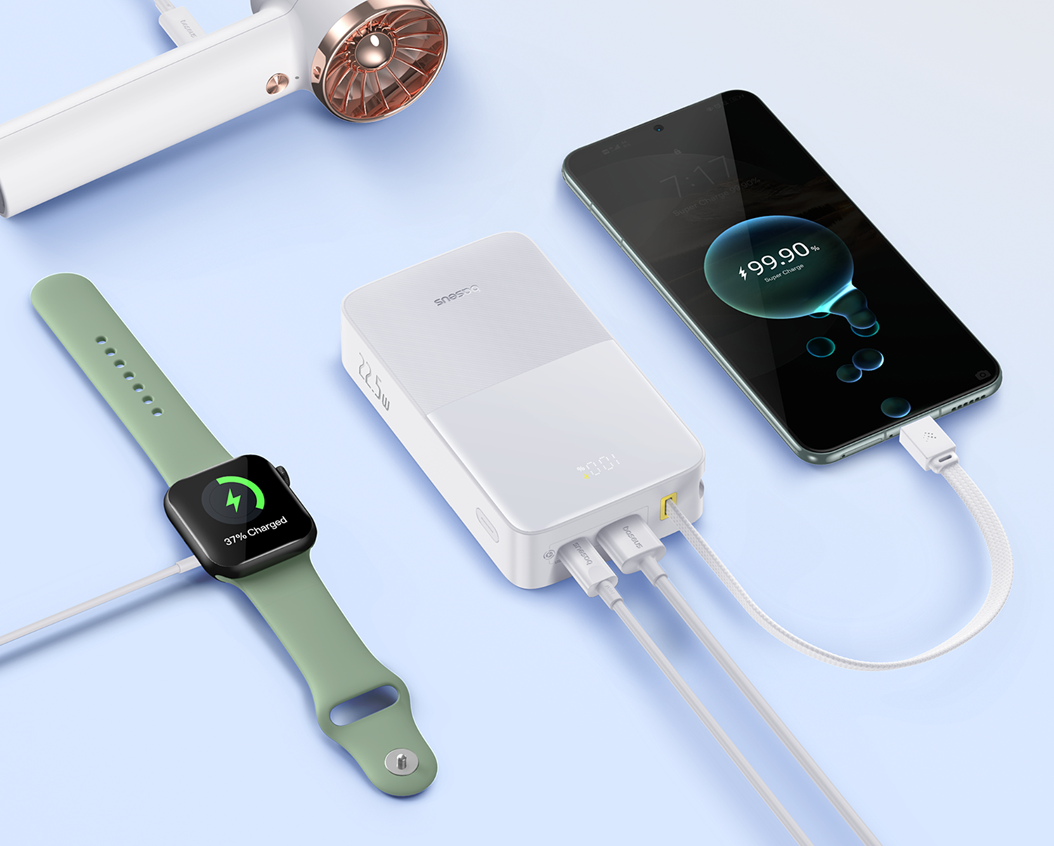 Un banco de energía blanco carga un smartwatch y un smartphone. Un secador de pelo arriba.
