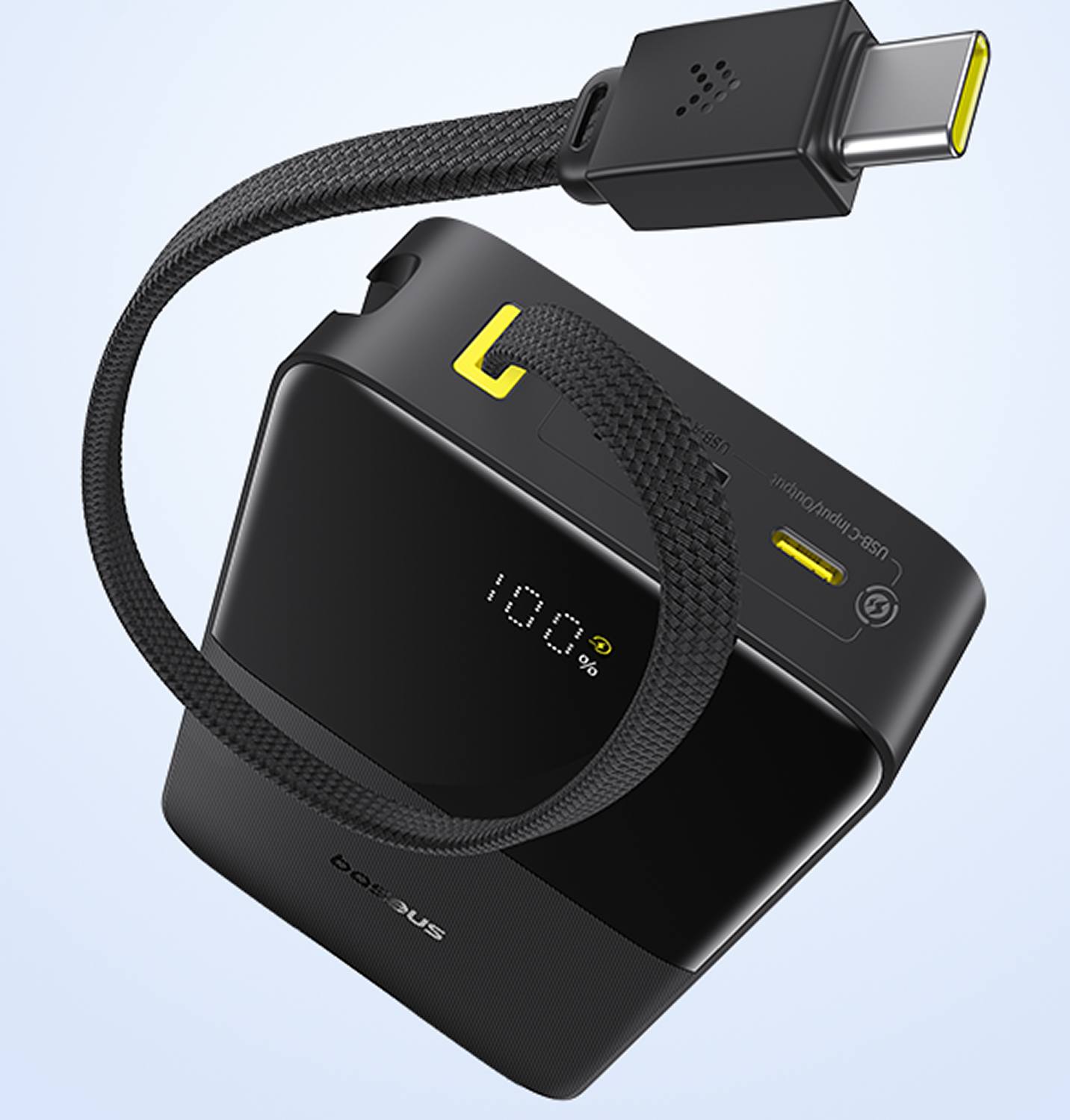 Batería externa negra con cable USB-C, muestra 100% de carga.