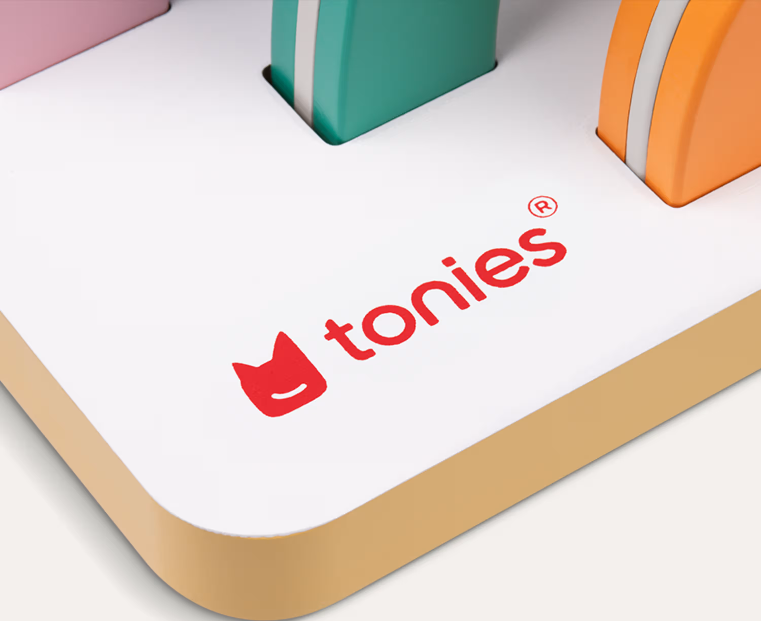 Tonies Logo auf einer weißen Oberfläche mit bunten Spielzeugblöcken.