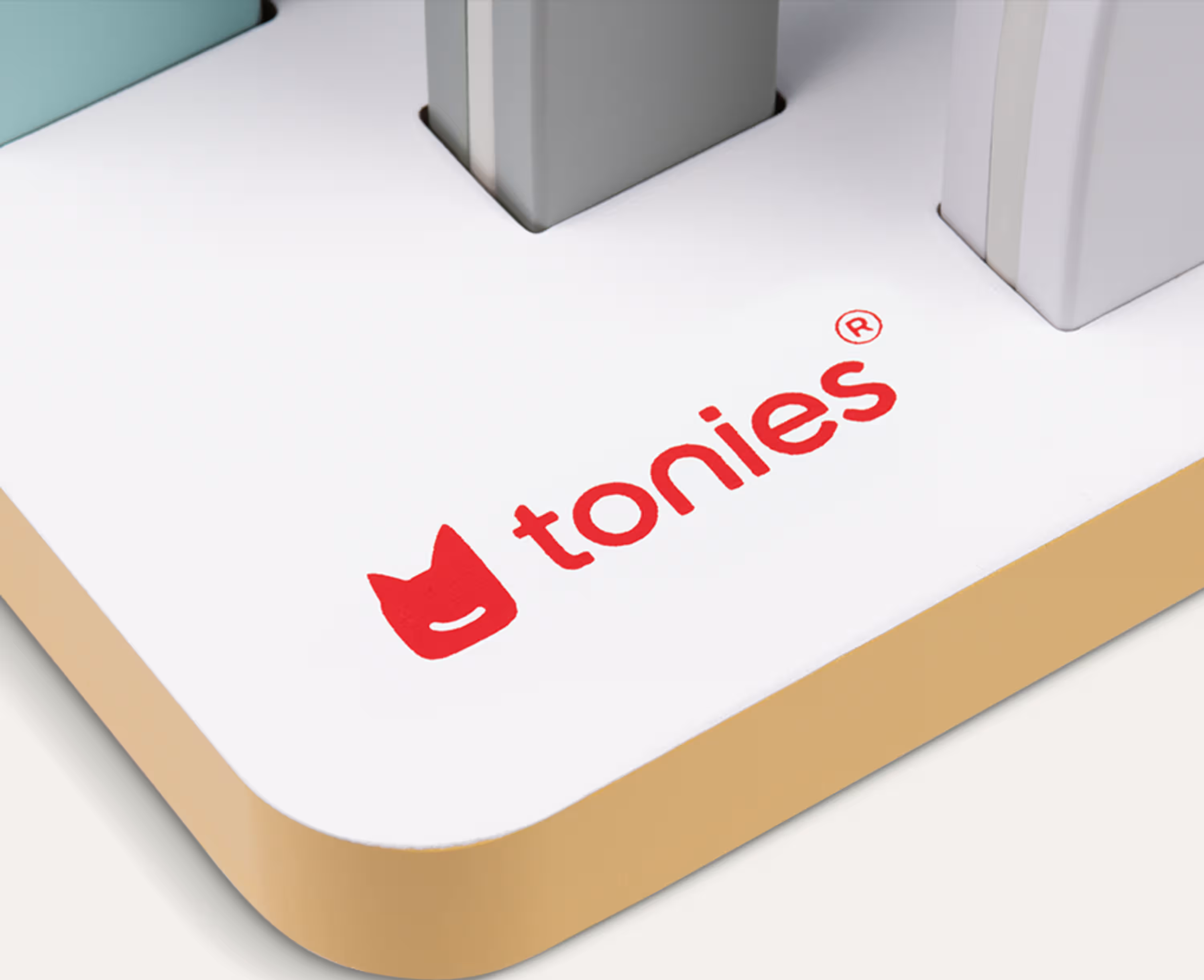Ein weißes Spielzeug mit rotem Tonies-Logo und grauen Blöcken.