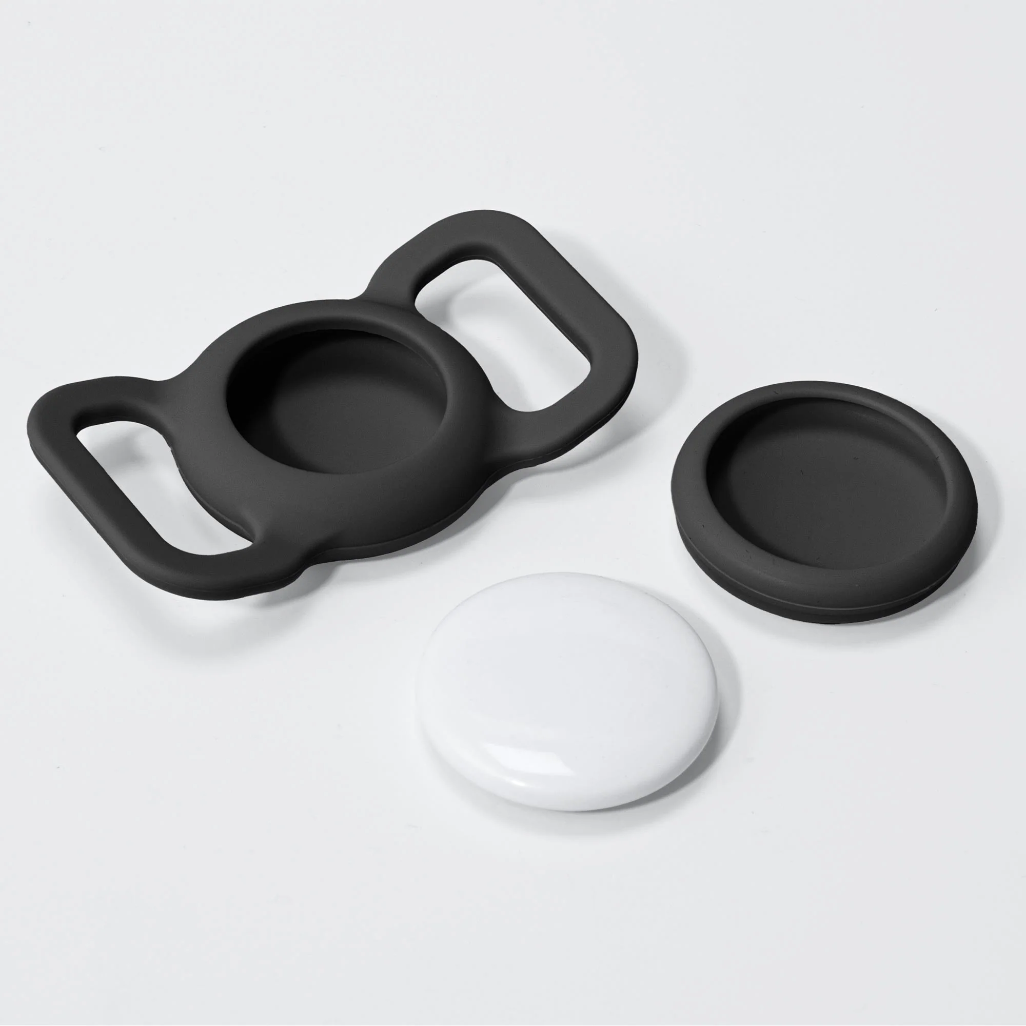 Un protecteur en silicone noir et un cercle blanc sur fond blanc.