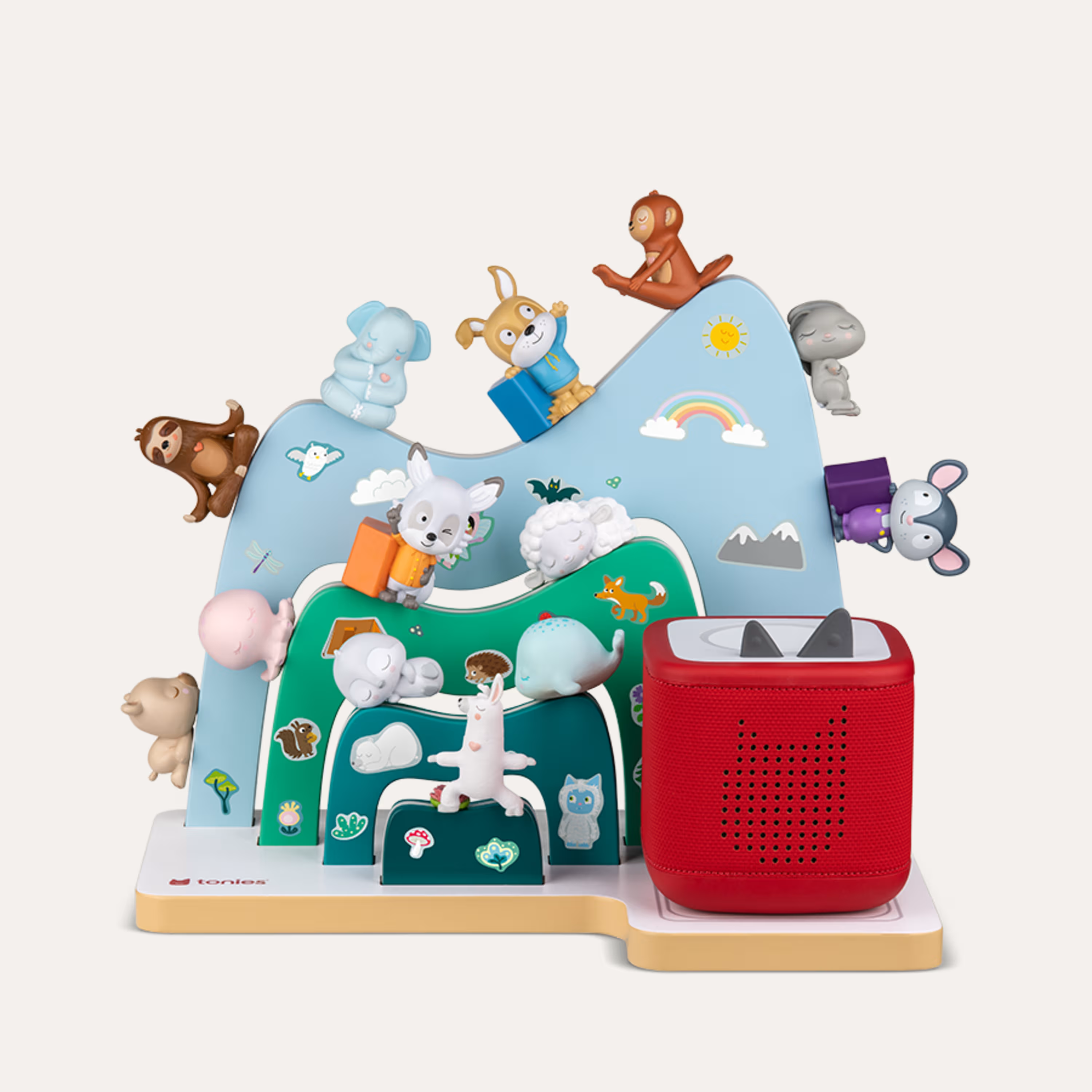 Ein bunter Spielzeugberg mit Tierfiguren und einem roten Lautsprecher.