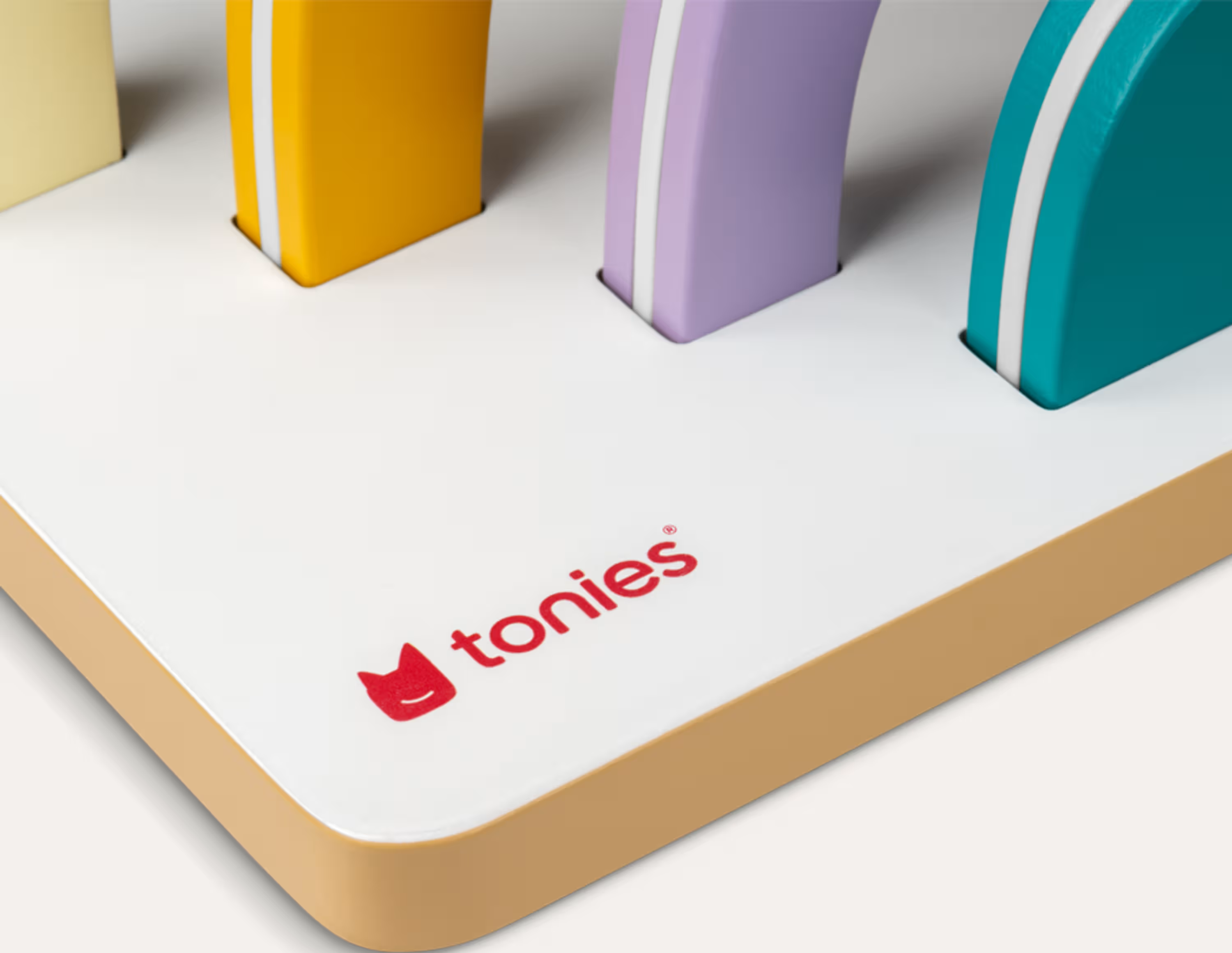 Bunte Holzklötze auf einer weißen Basis mit dem Tonie-Logo.