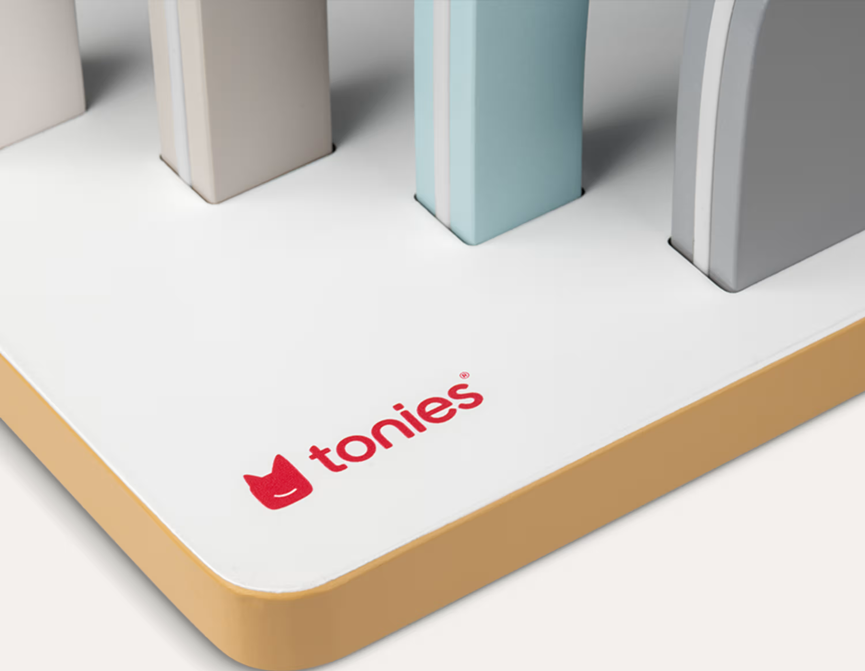 Tonies-Logo auf einem weißen Podest mit bunten Blöcken.