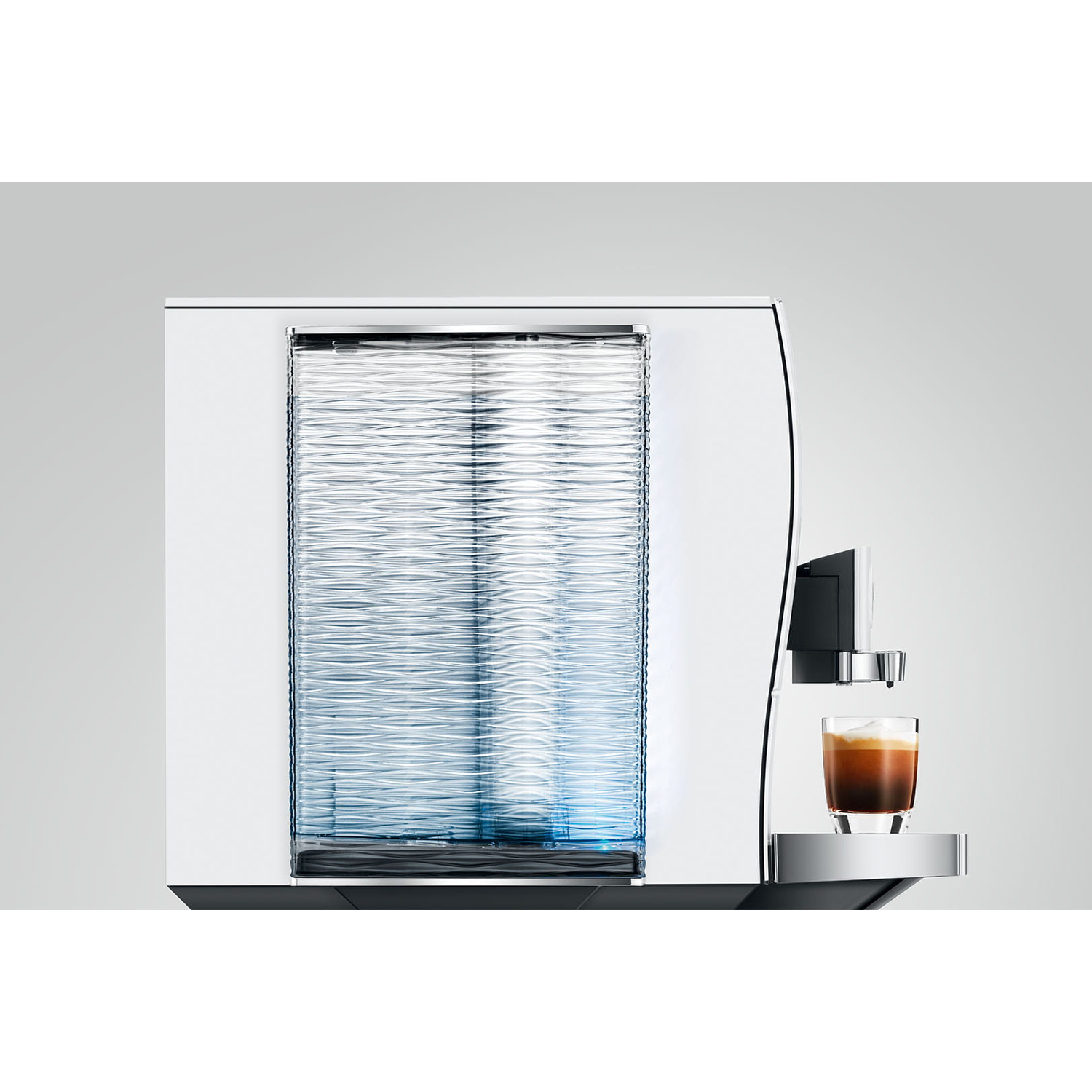 Een witte koffiemachine met een glas espresso erop, tegen een grijze achtergrond.
