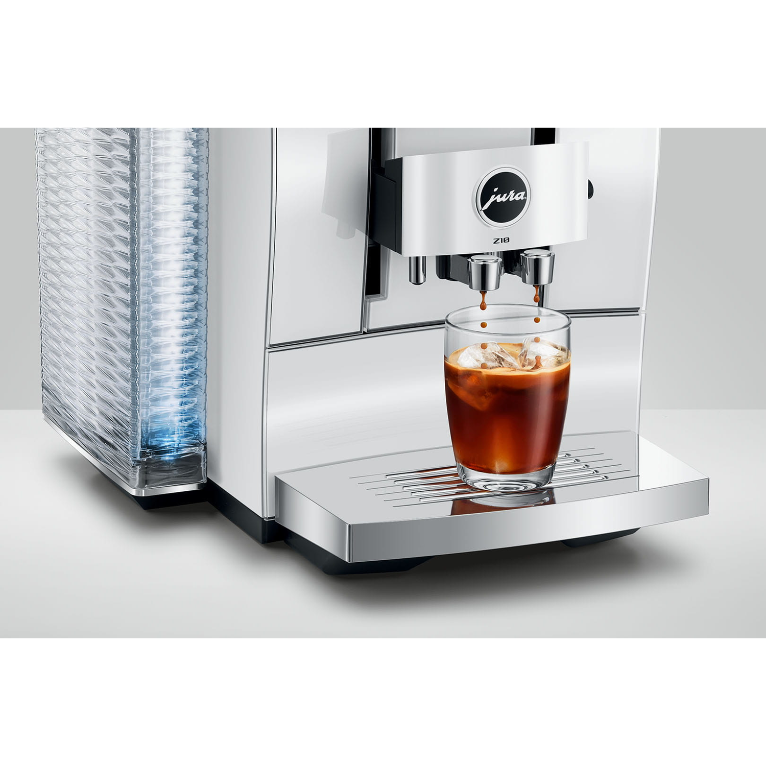 Een koffiezetapparaat brouwt koffie in een glas met ijs. Links een stapel bekers.