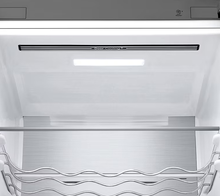 Wnętrze lodówki z półkami i paskiem świetlnym z napisem Door Cooling+.
