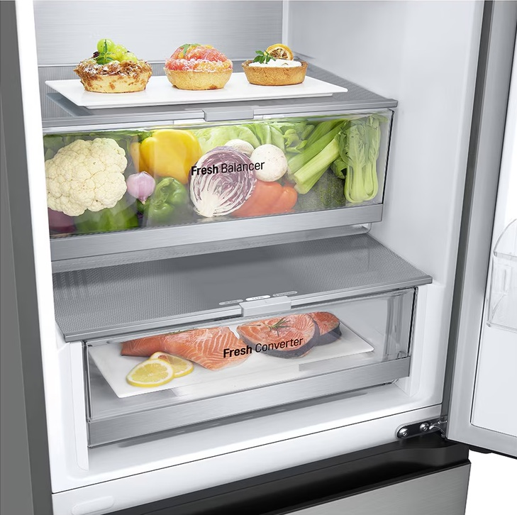 Wnętrze lodówki: desery na górnej półce, warzywa w środkowej szufladzie, łosoś w dolnej szufladzie.