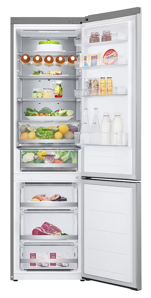 Otwarta lodówka wypełniona jedzeniem: owoce, warzywa, mięso, ryby i napoje.