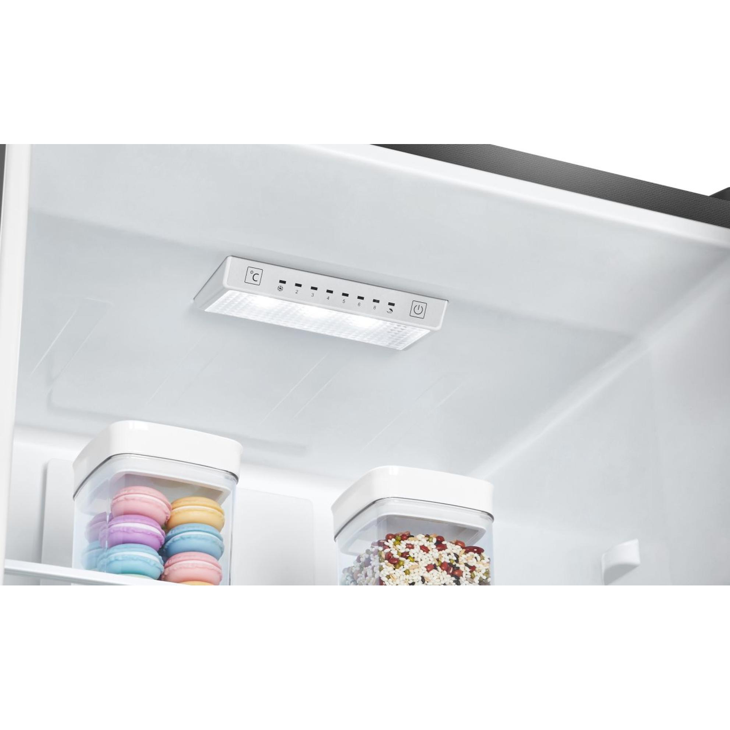 Interior view of a refrigerator with two containers, one with colorful macarons and one with beans.